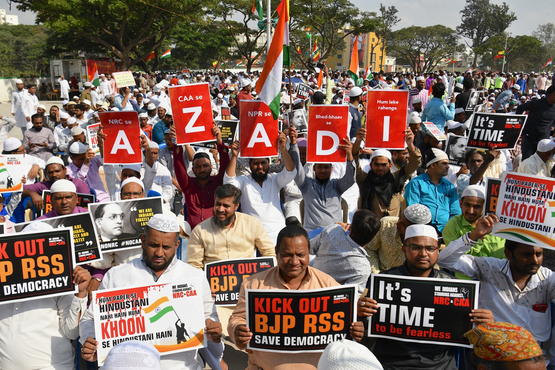 Muslim protesters hold placards and wave Indian flags during a rally against India’s new citizenship law in Bangalore on January 3, 2020