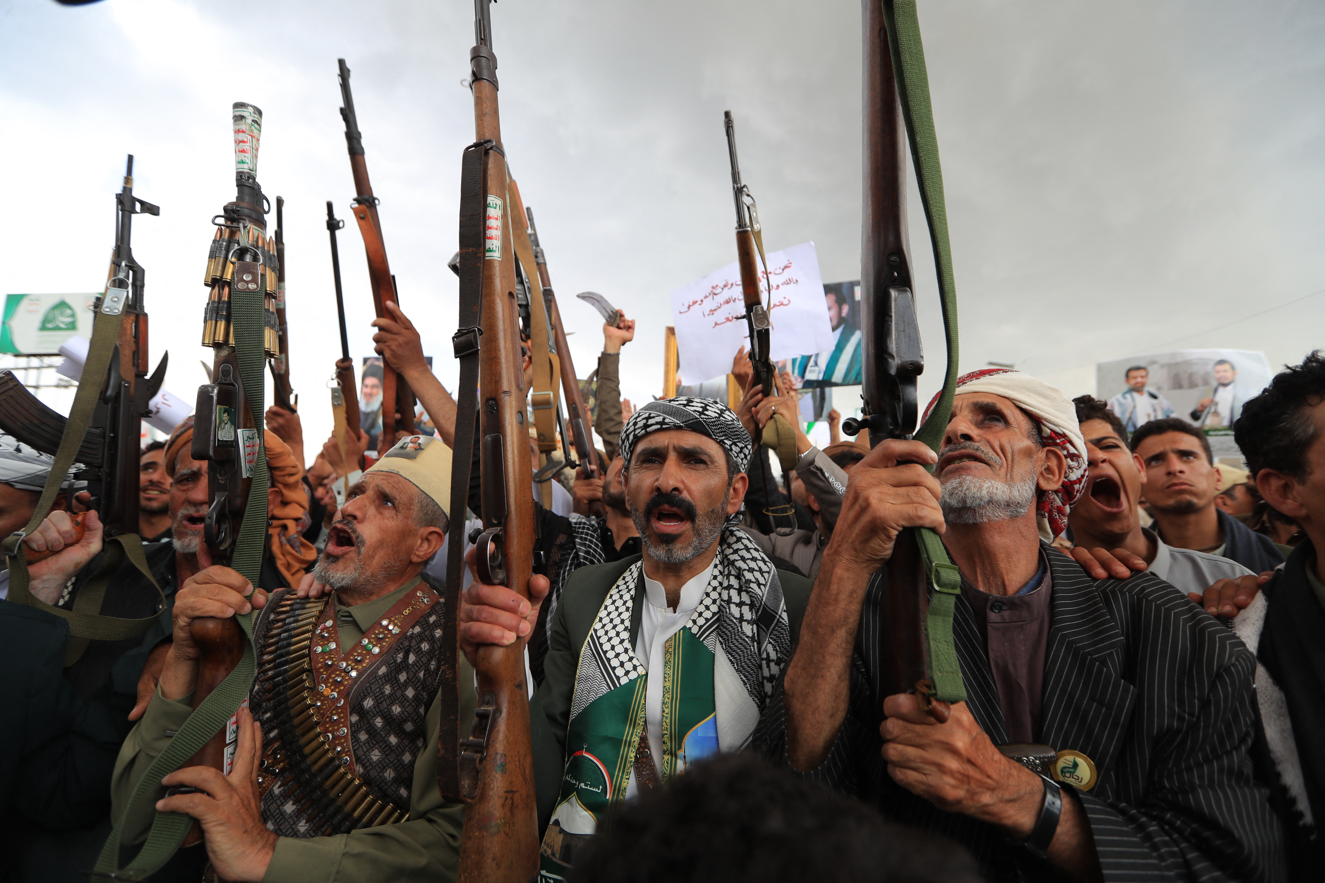 Armed protesters brandish their weapons and placards