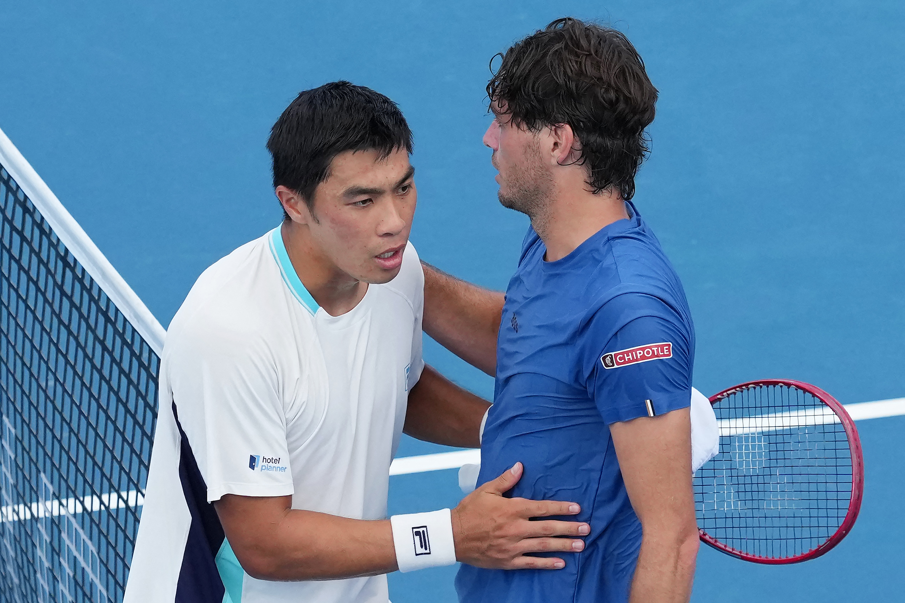 United States tennis players Brandon Nakashima, left, and Taylor Fritz shake hands at the net.