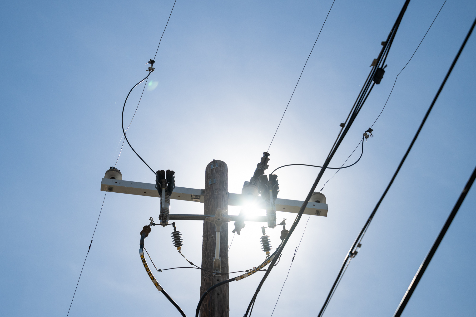 The sun shines through a power line during record-breaking heat Thursday, March 19, 2026, in Tempe, Ariz. (AP Photo/Caitlin O'Hara)