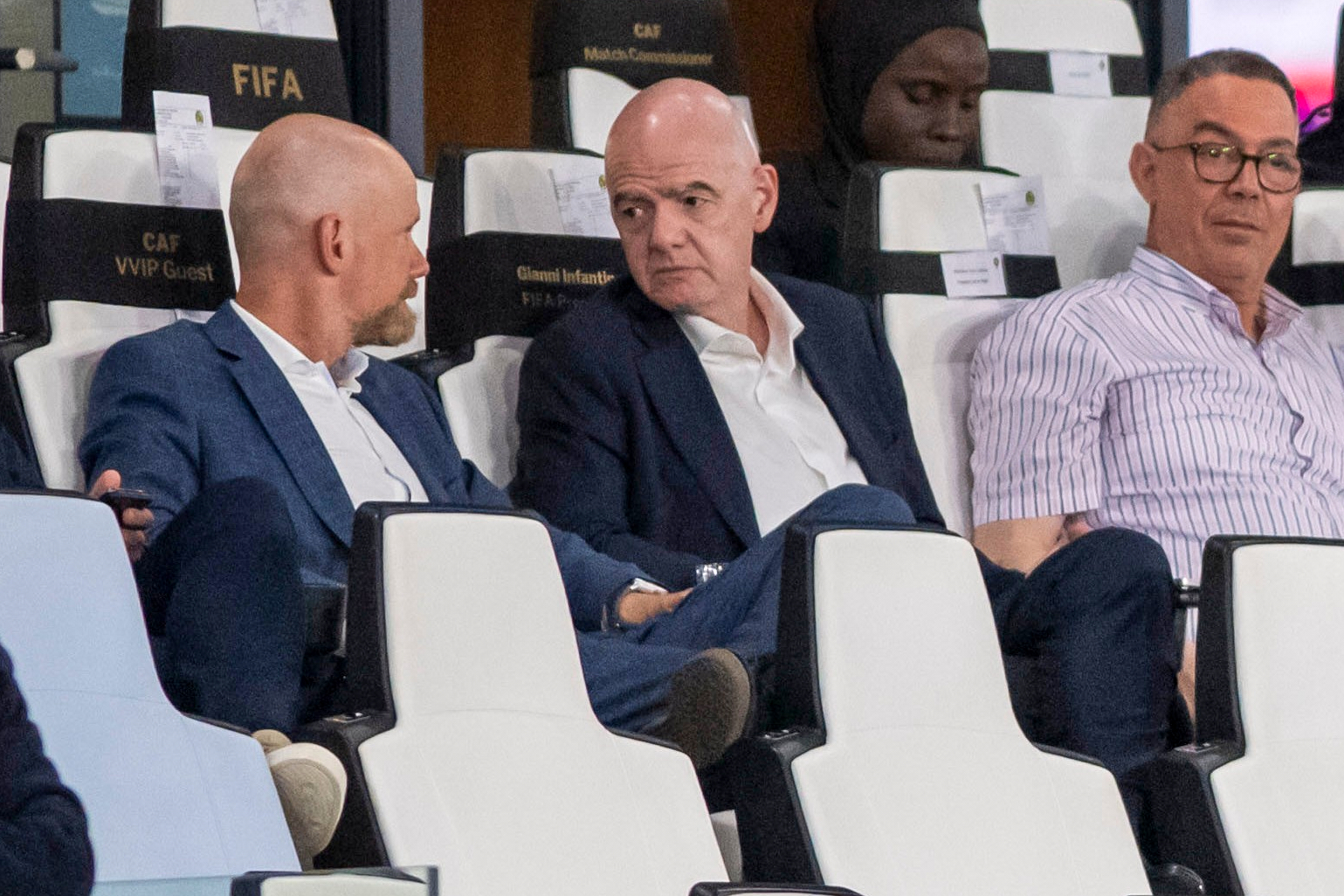 FIFA president Gianni Infantino, center, speaks to FIFA secretary general Mattias Grafstrom, left, sitting beside president of Moroccan Royal Football Federation Fouzi Lekjaa as they attend a Women's AFCON 2026 soccer match between Malawi and Zambia