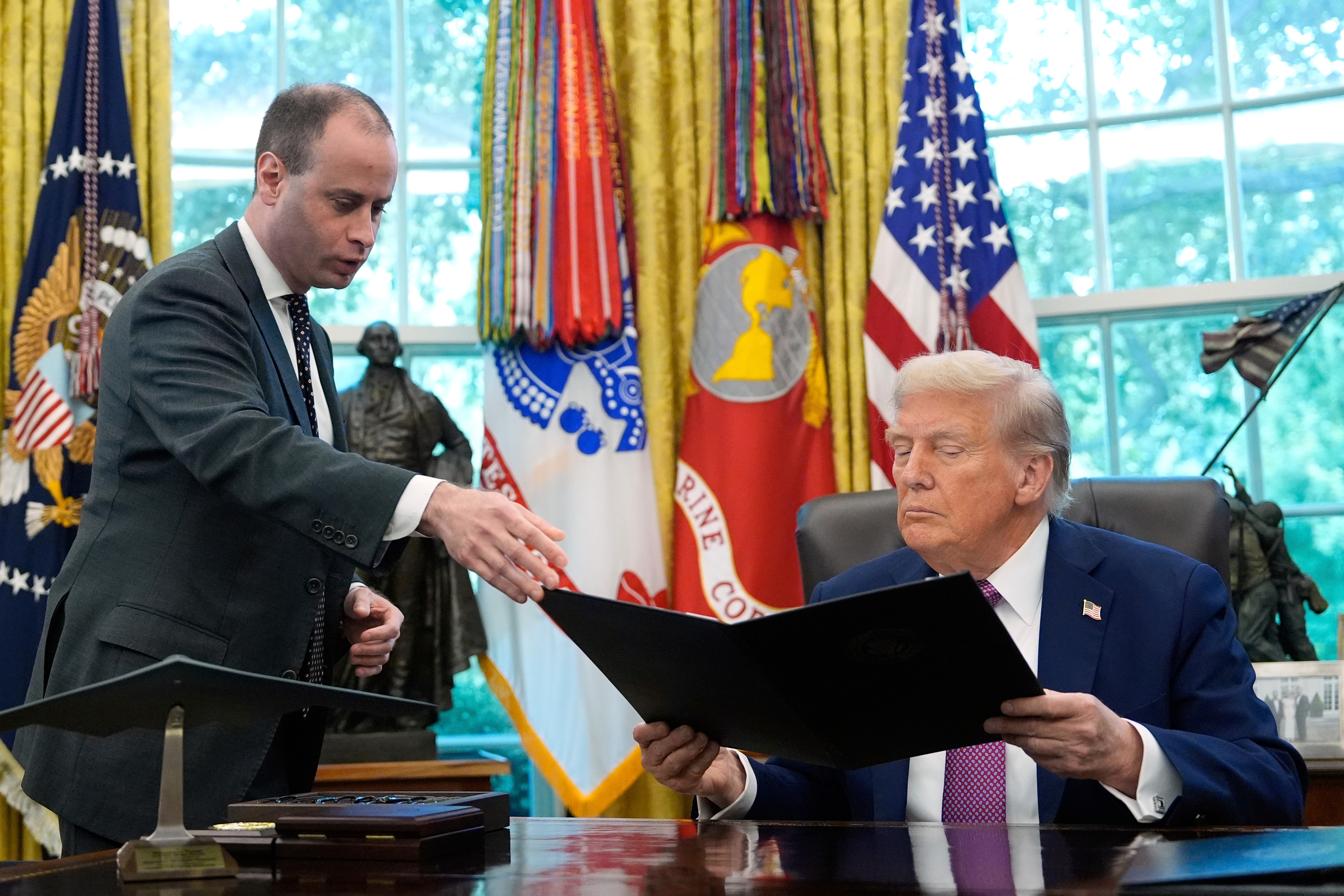 FILE - White House staff secretary Will Scharf, left, hands President Donald Trump an executive order to sign in the Oval Office of the White House, Sept. 5, 2025, in Washington. (AP Photo/Alex Brandon, File)