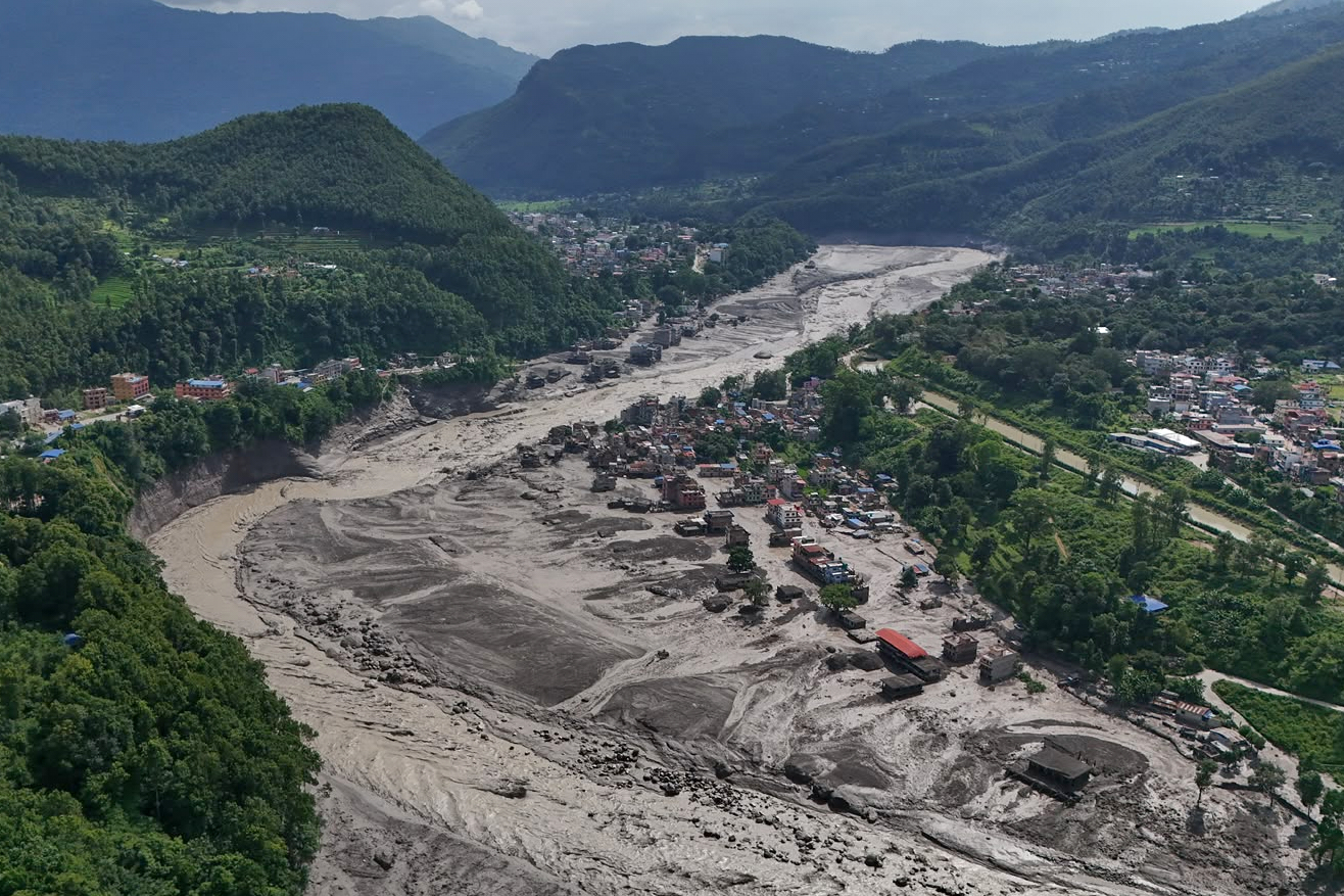 Damaged houses stand precariously near the swollen, debris-choked banks of the Trishuli River after flash floods in Nepal’s Nuwakot district on Wednesday