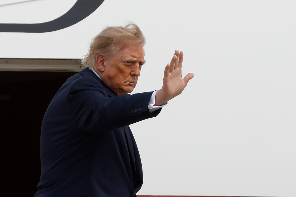 Trump waves after exiting a plane