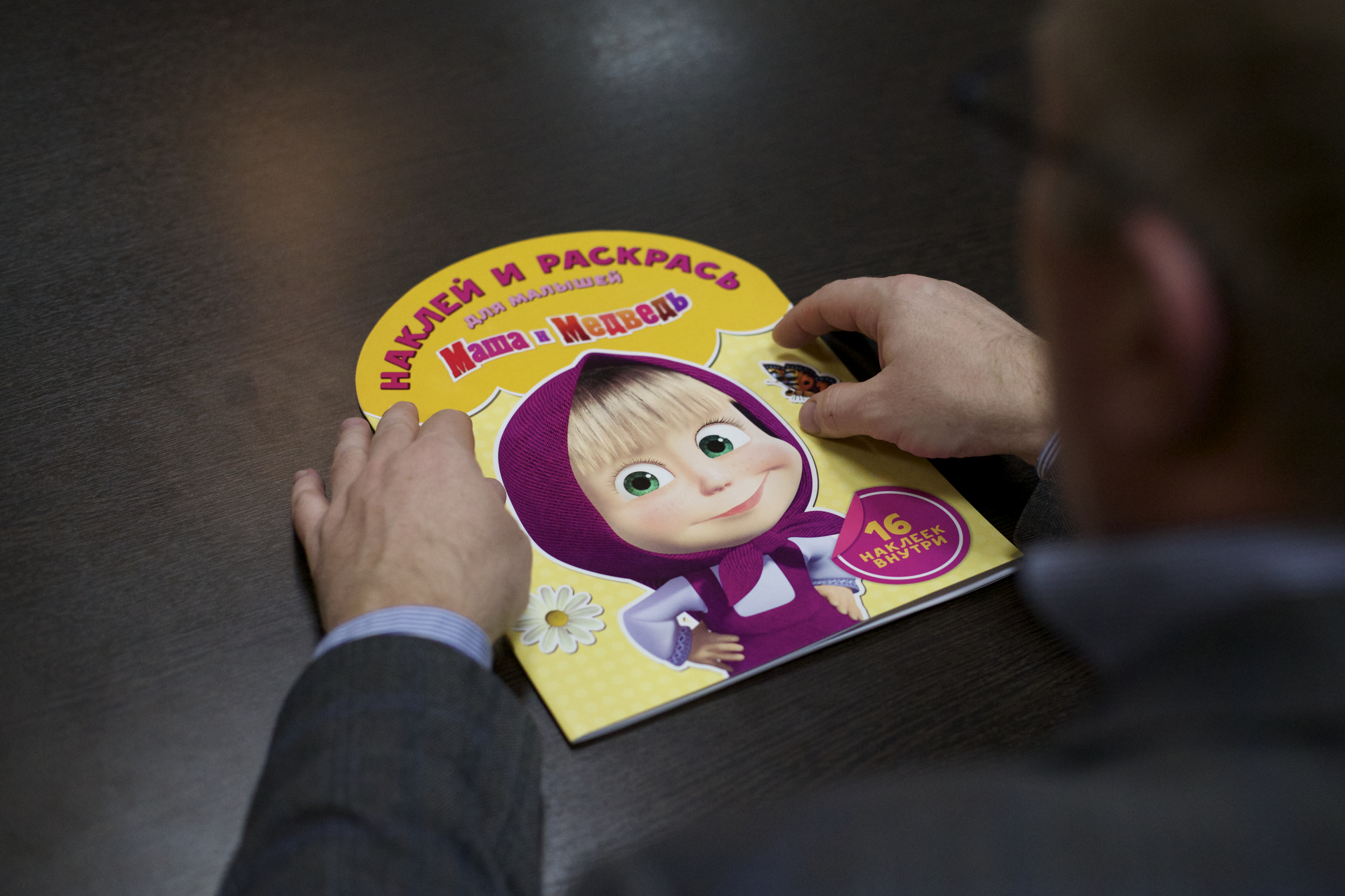 Dmitry Loveyko, a managing director of Animaccord which produces the Masha and Bear cartoon series holds a children's book [Ivan Sekretarev/AP]