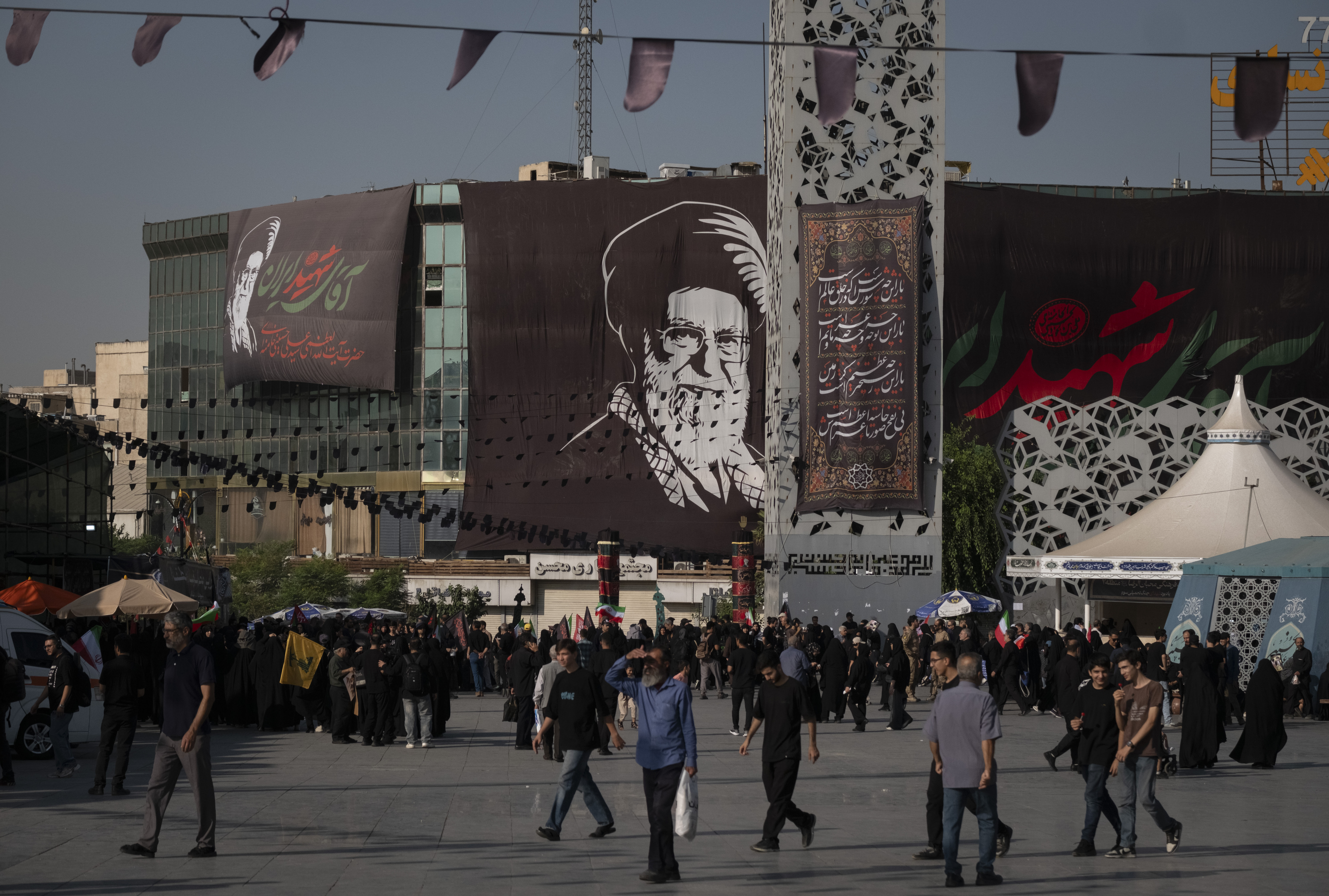 Pro-government mourners walk beneath a portrait of Iran's Late Supreme Leader, Ayatollah Ali Khamenei, during a religious rally marking Arbaeen, in the holy month of Muharram, in southern Tehran, Iran, on August 4, 2026, amid tensions between Iran and the U.S.