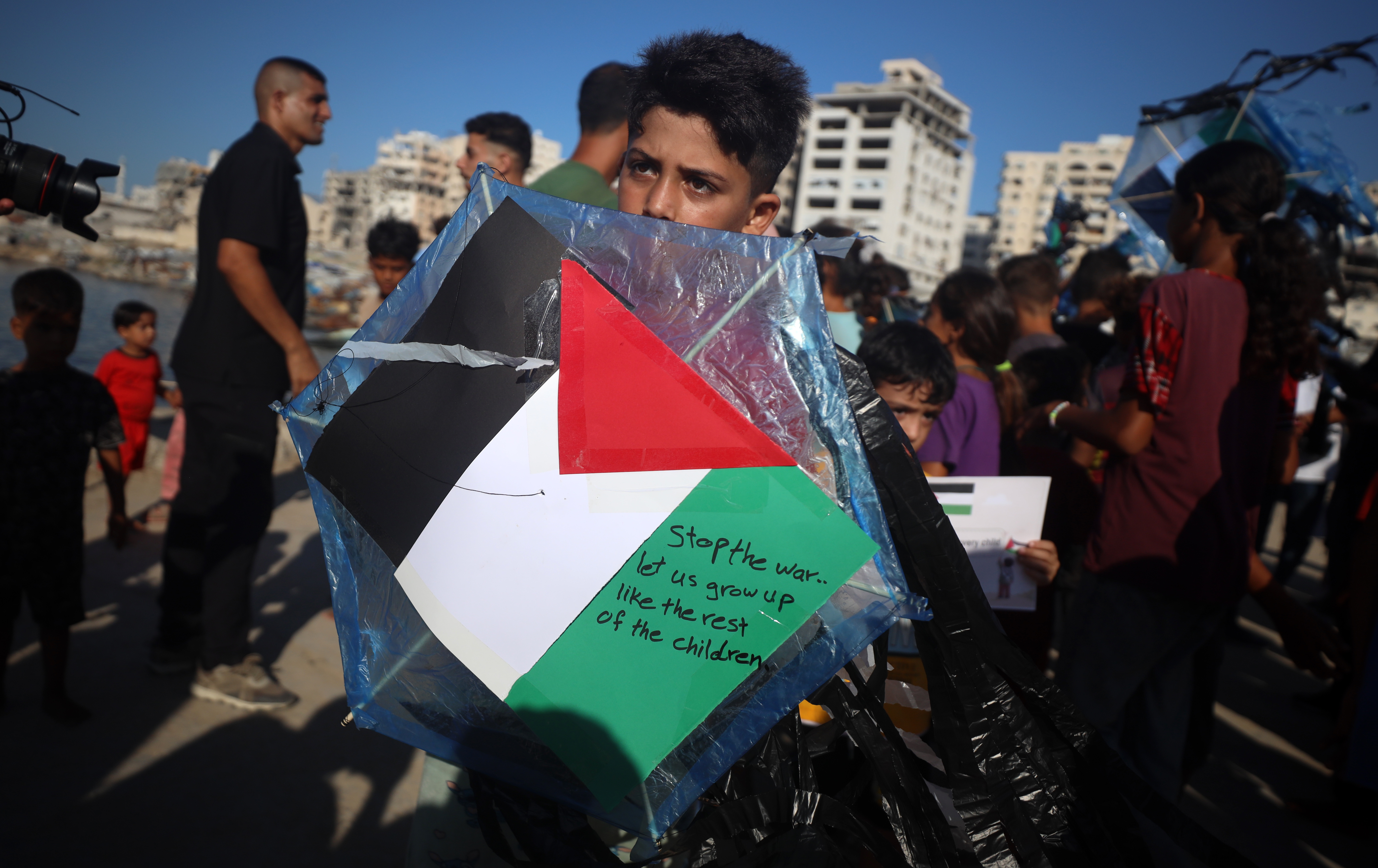 Palestinian children hold kites during a gathering at Gaza Port