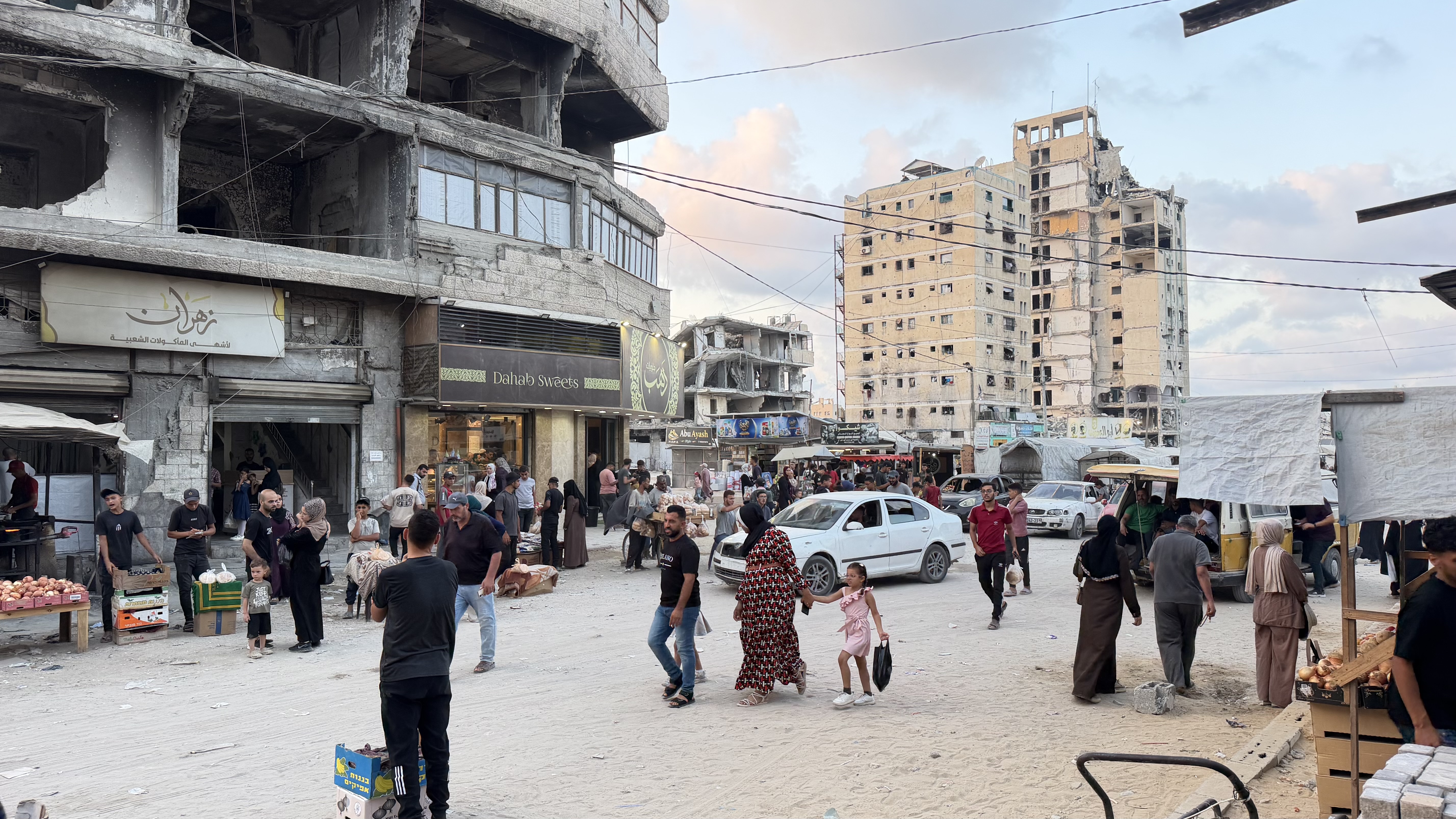 People walk in Gaza City's Bahloul Junction, where stores provide free internet, allowing people nearby to make online payments