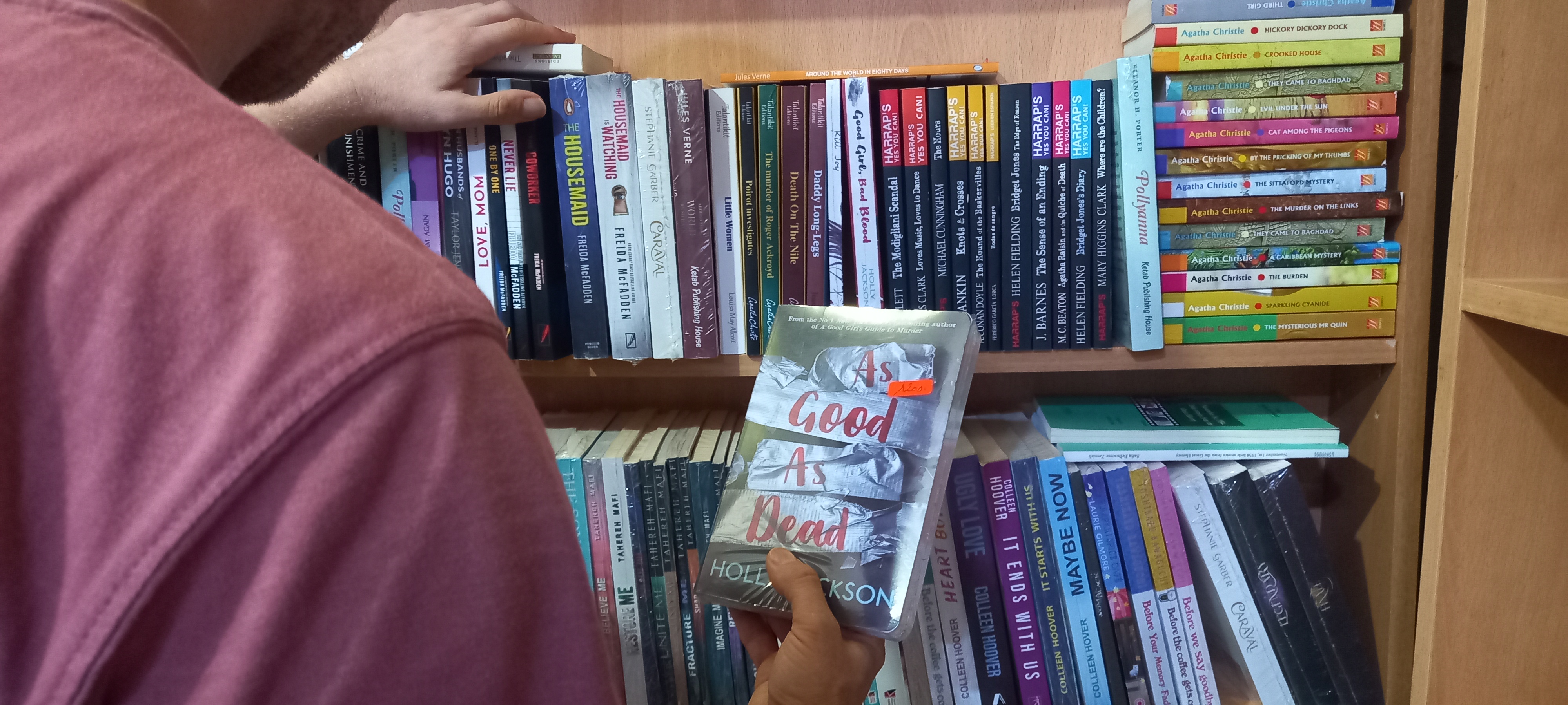 Shelves of English-language books at the Librairie Libre Pensée in Tizi-Ouzou. Even before French recedes in public life, younger Algerians are turning to English — drawn less to the classics than to contemporary fiction and popular titles, a generational shift reshaping reading habits across the country [Madjid Serrah/Al Jazeera]