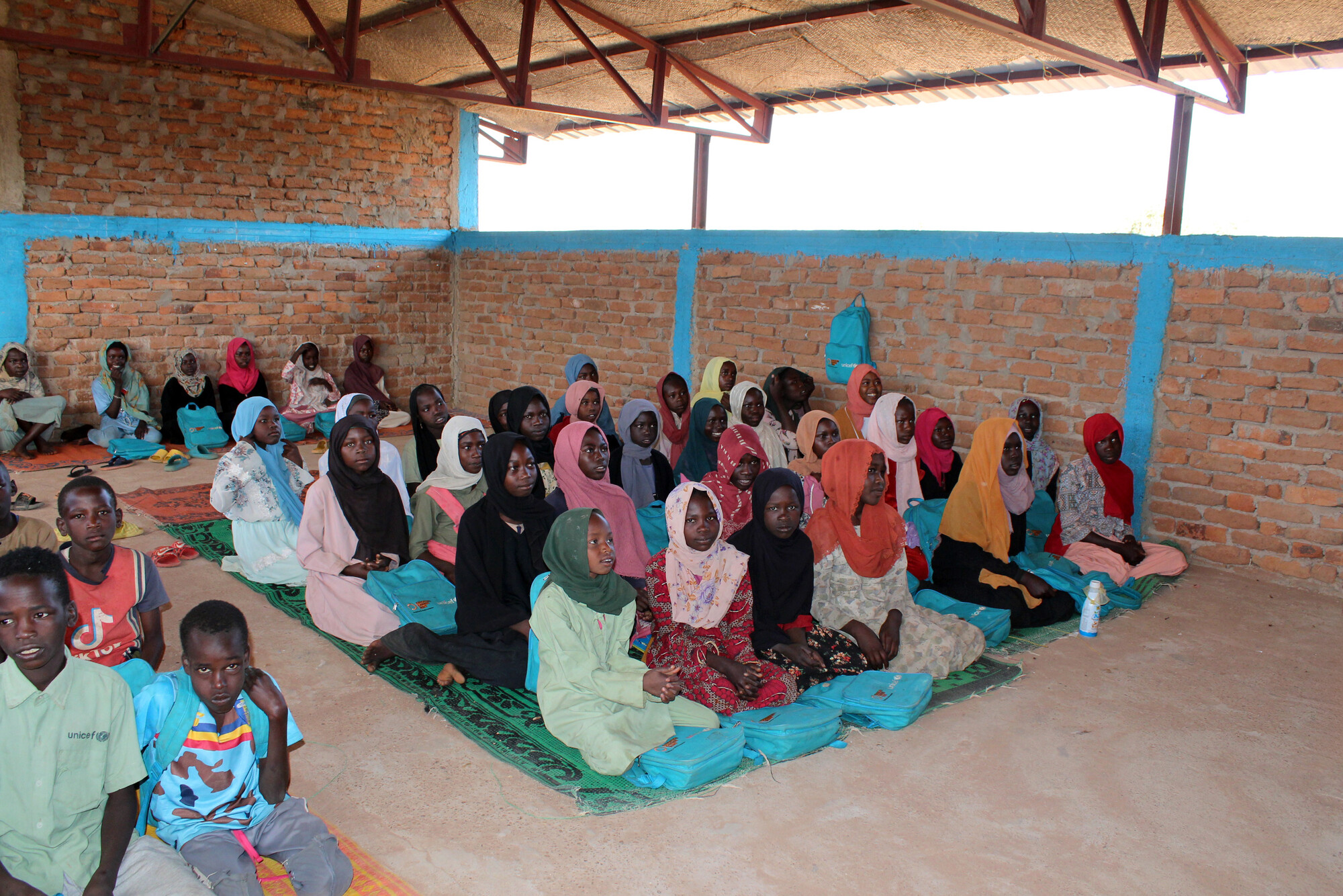 Sudanese and Chadian children attend class together at a refugee camp school in eastern Chad, where teachers from the refugee community help provide education for displaced families. [Courtesy of Plan International]