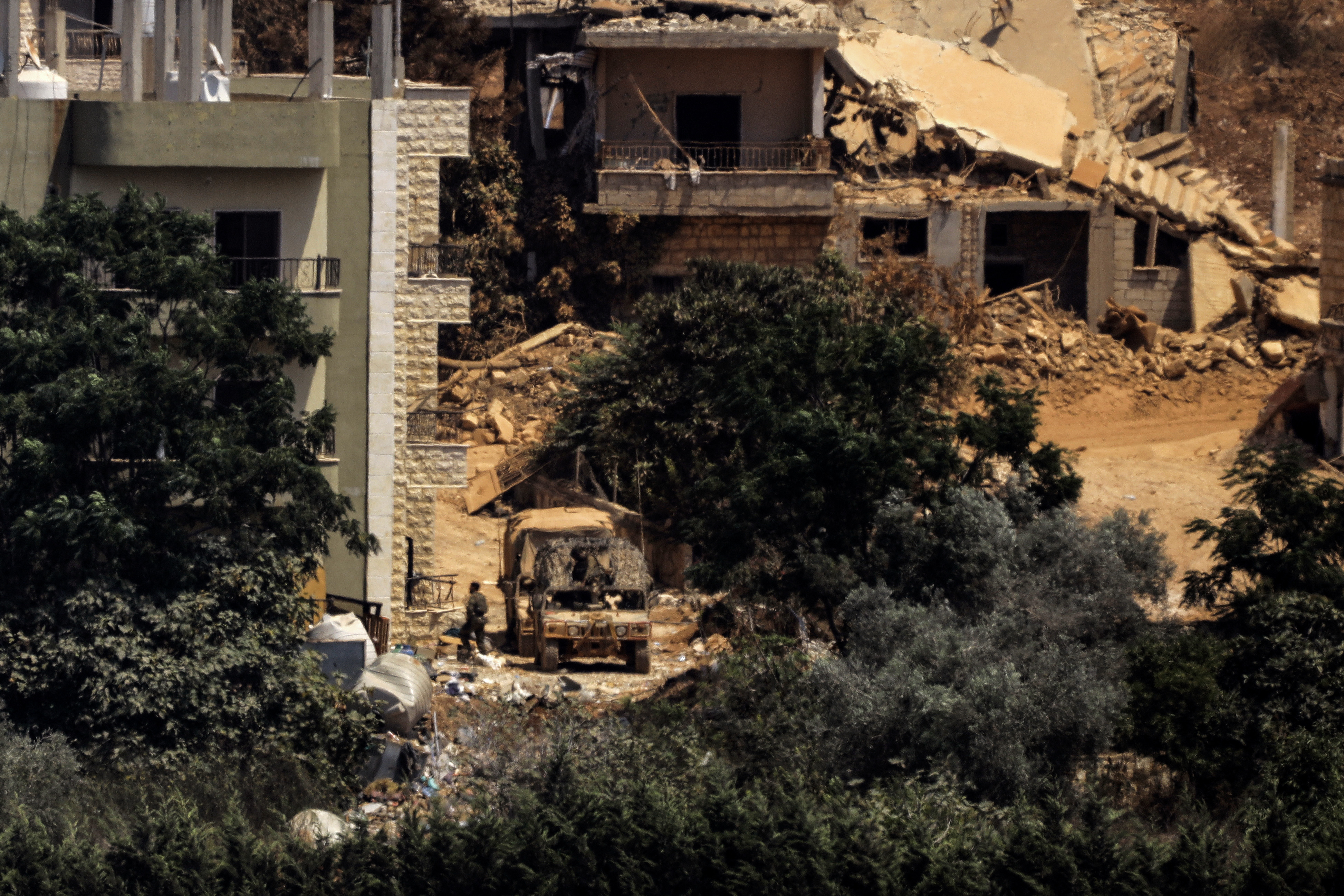 This picture taken from the southern Lebanese village of Zawtar al-Gharbiyah shows Israeli humvees stationed between houses in the nearby village of Zawtar al-Charkiyah on August 13, 2026.