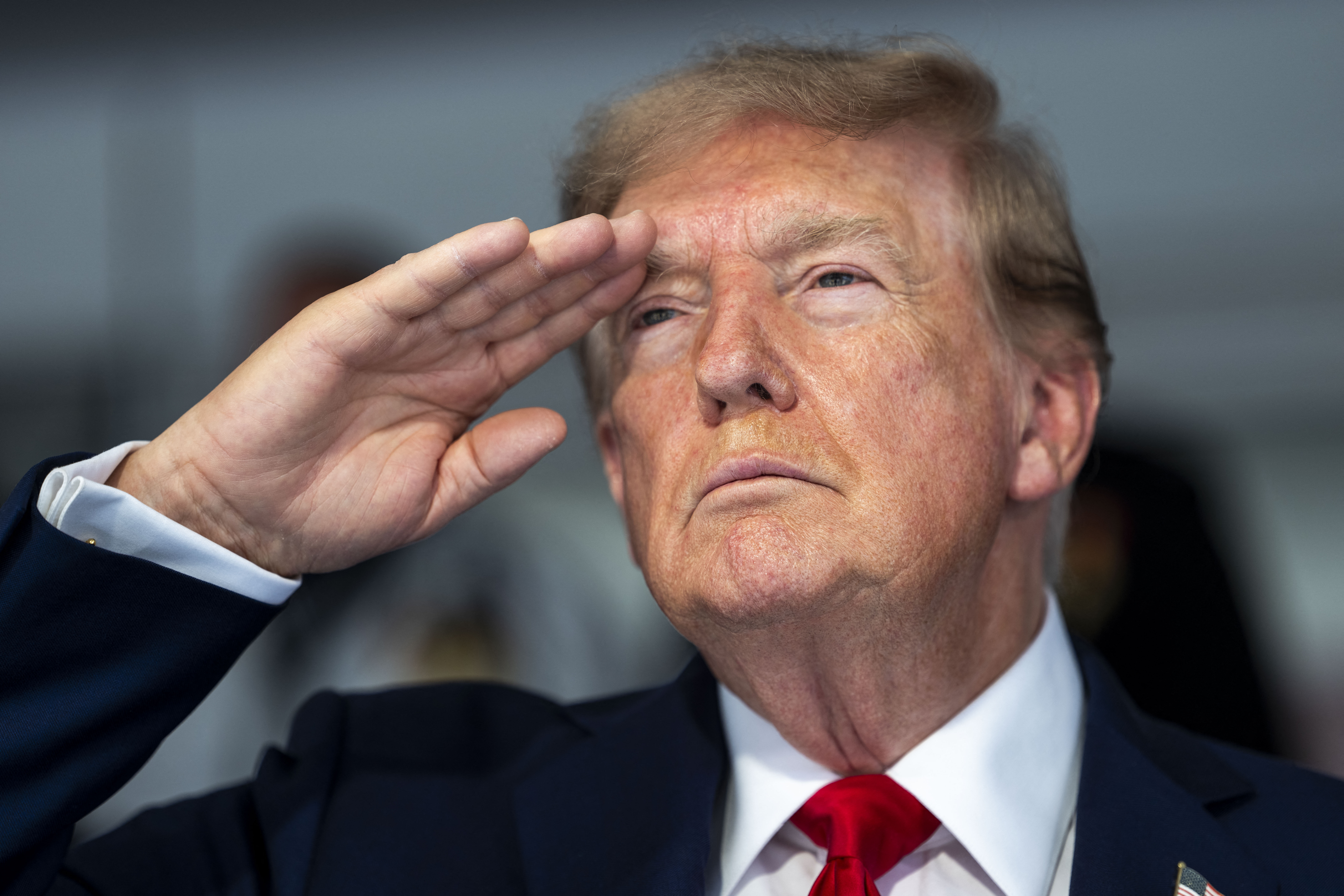 US President Donald Trump salutes during the national anthem at the start of the race, during the Freedom 250 Grand Prix Race on the streets of Washington, DC, on August 23, 2026.
