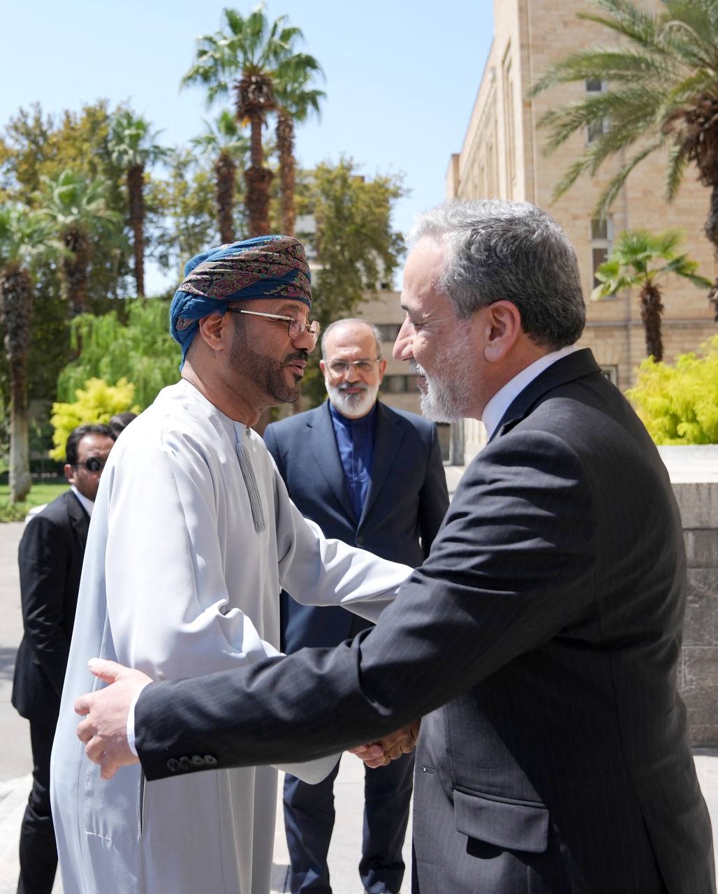 Iranian Foreign Minister Abbas Araghchi (R) greets Oman's Foreign Minister Badr Albusaidi (L).