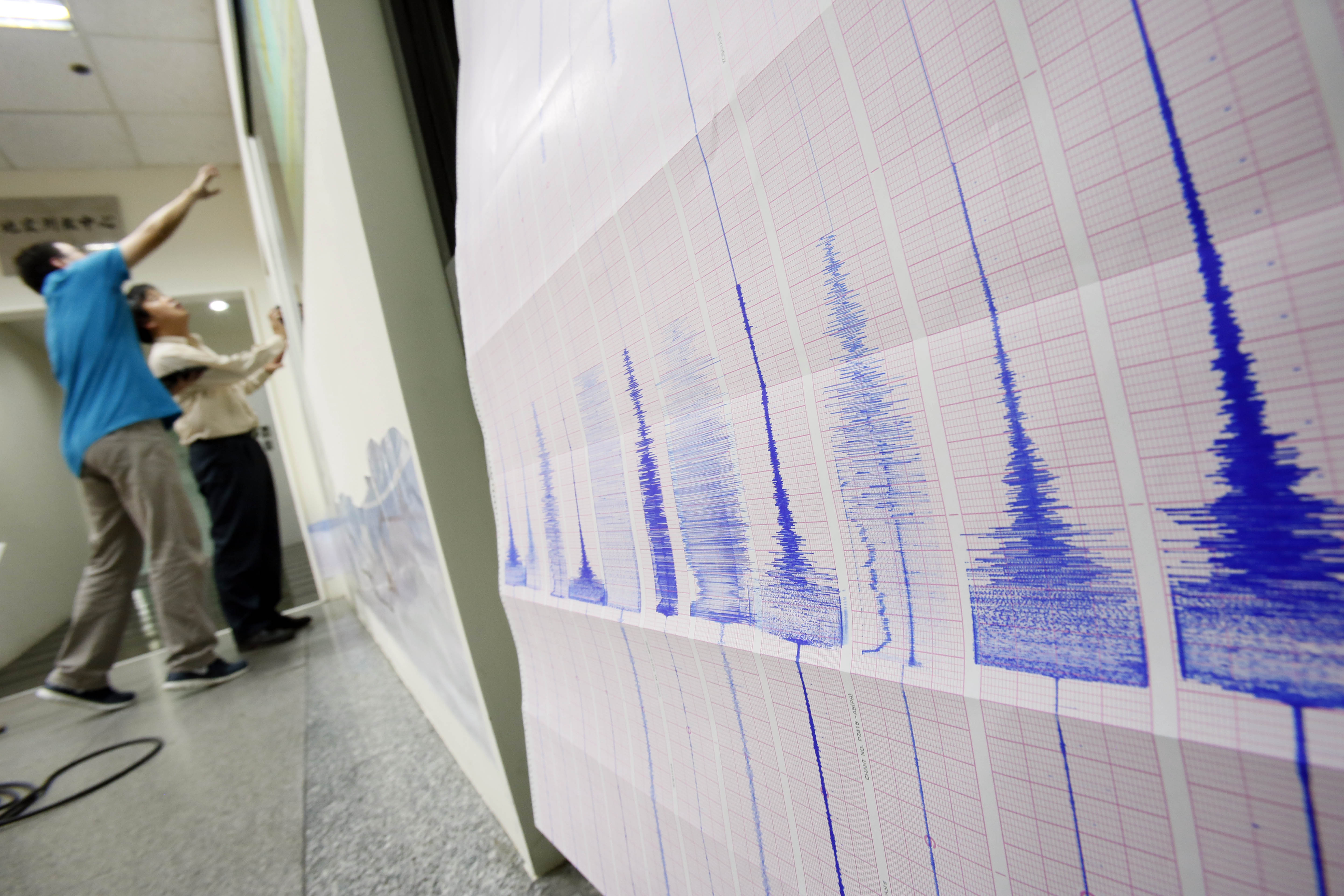 Seismogram recordings of a strong earthquake that shook the island print out as seismologists chart the epicenter map at the Seismology Center in Taipei, Taiwan, late Thursday, Oct. 31, 2013. The U.S. Geological Survey said the earthquake struck at 8:02 p.m. and measured magnitude 6.3. It was centered in a remote mountainous area 45 kilometers (28 miles) south-southwest of the coastal city of Hualian at a depth of just 12 kilometers (7.5 miles). There were no immediate reports of serious damage or casualties. (AP Photo/Wally Santana)