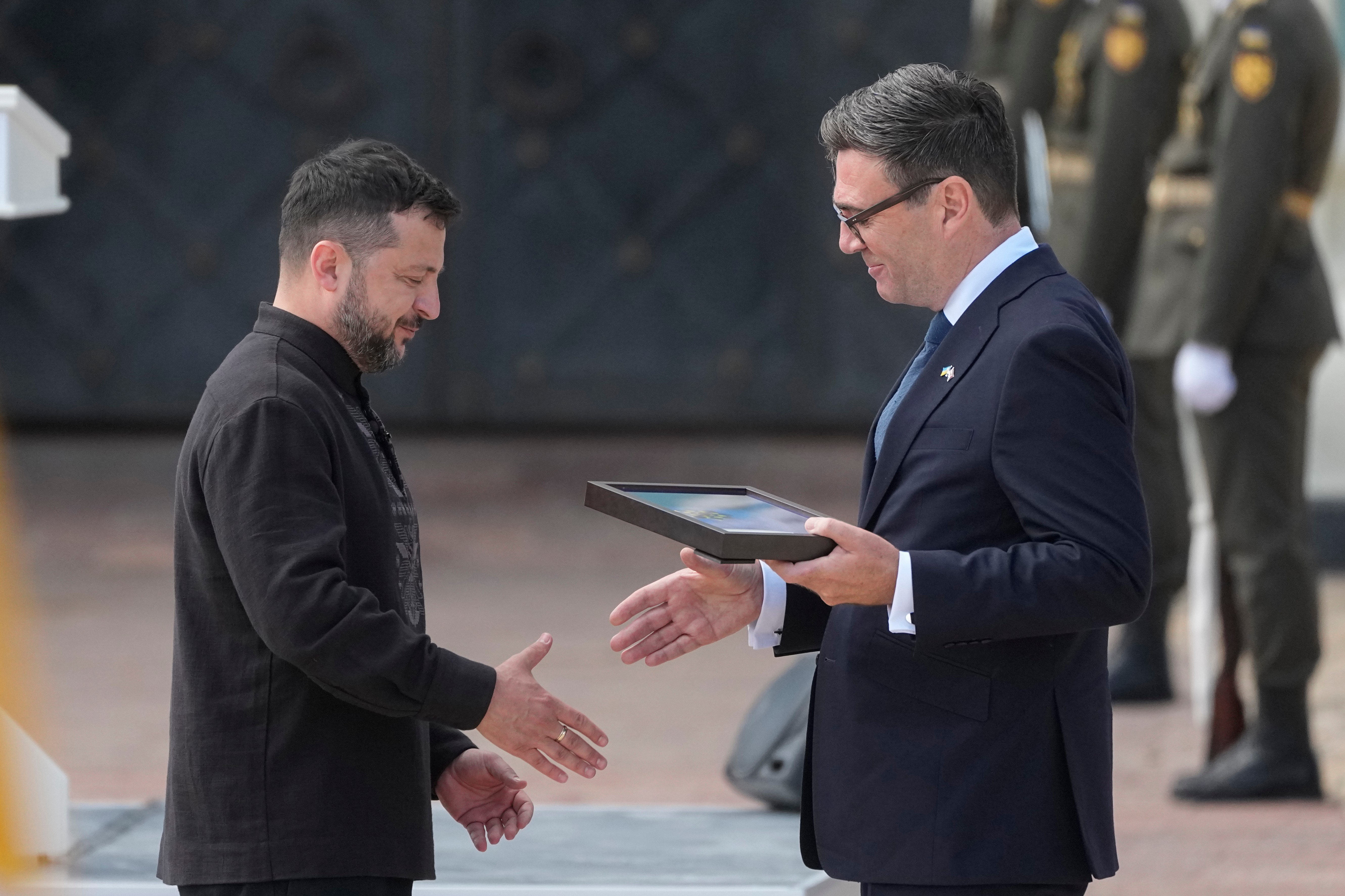 Ukrainian President Volodymyr Zelenskyy, left, and Britain's Prime Minister Andy Burnham shake hands during a commemorative ceremony in Kyiv, Ukraine, Monday, Aug. 24, 2026, marking Ukraine's 35th Independence Day. (AP Photo/Efrem Lukatsky)