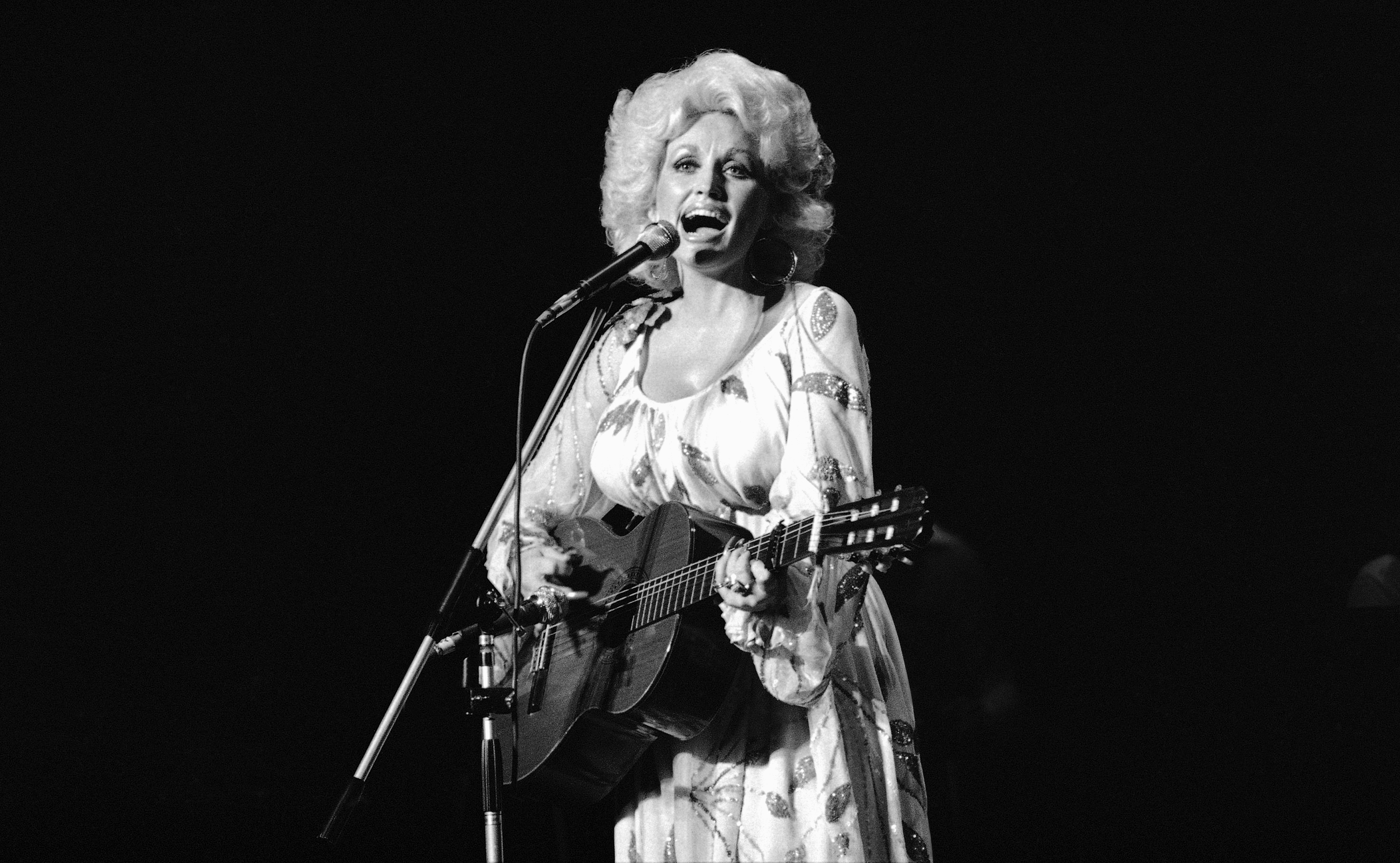 Dolly Parton performs in concert with a guitar