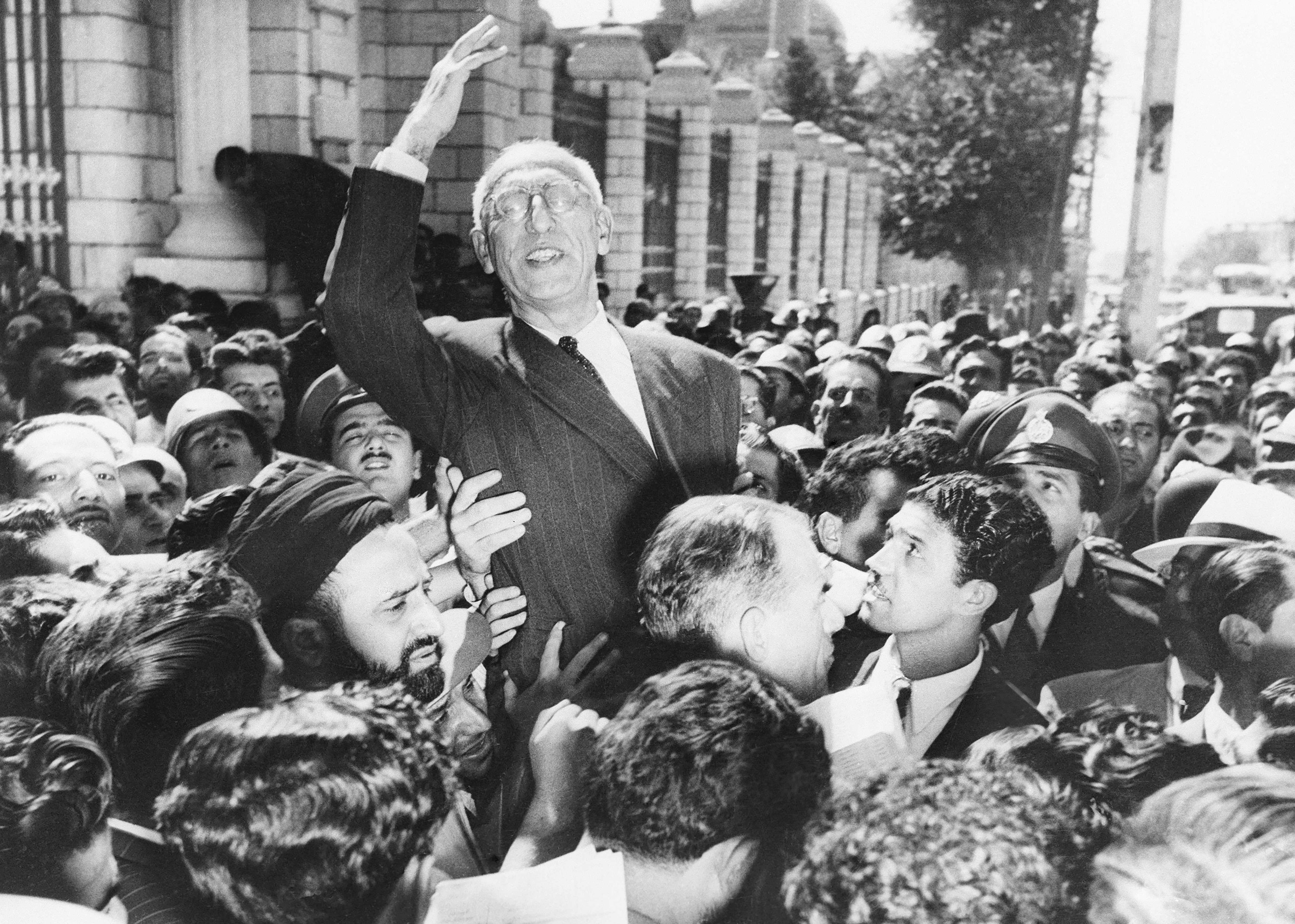 Prime Minister Mohammad Mossadegh rides on the shoulders of cheering crowds in Tehran's Majlis Square, outside the parliament building, after reiterating his oil nationalisation views to his supporters on Sep 27, 1951