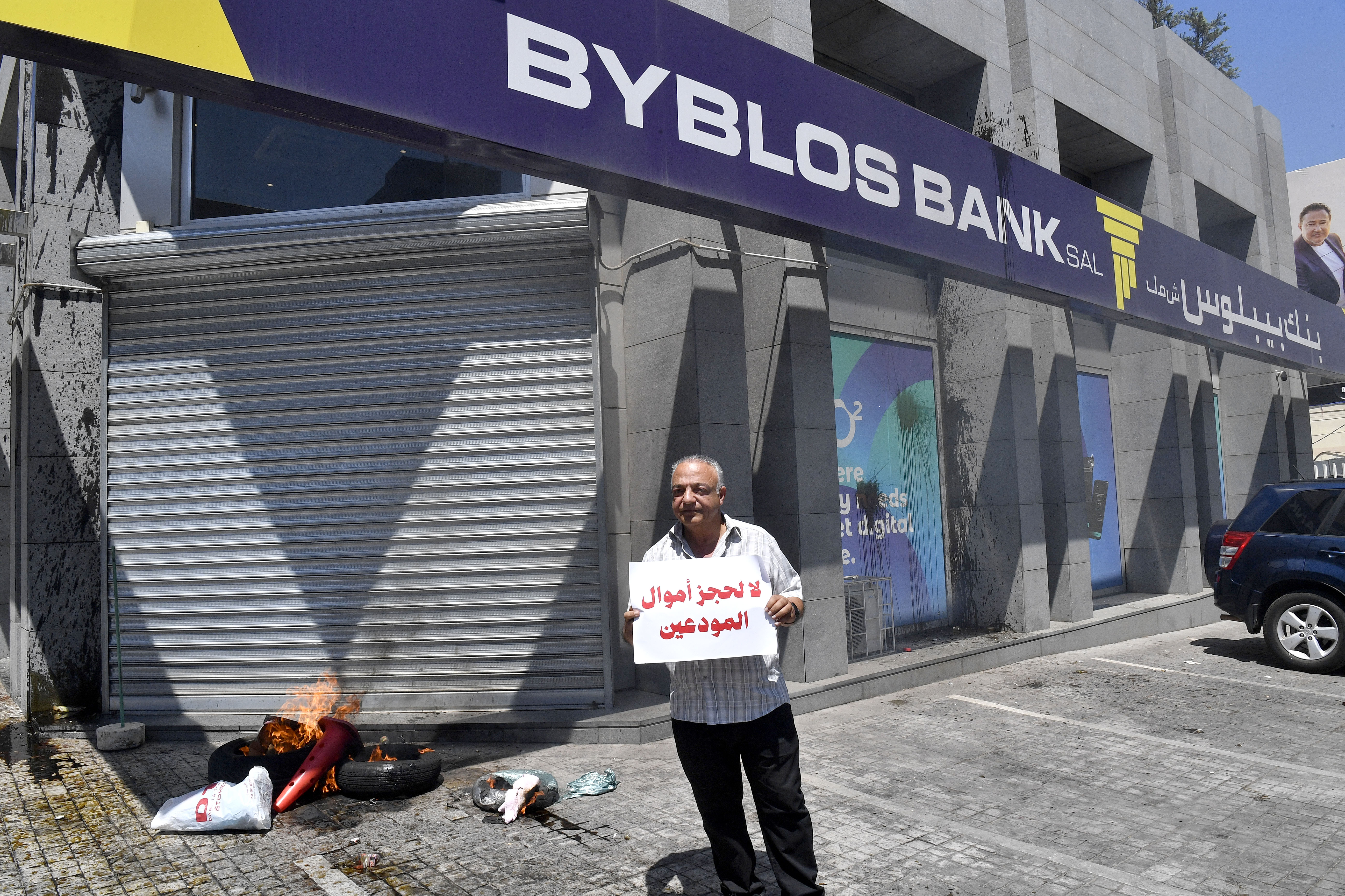 A man holds a banner reading 'No to freezing depositors' funds' during a demonstration.
