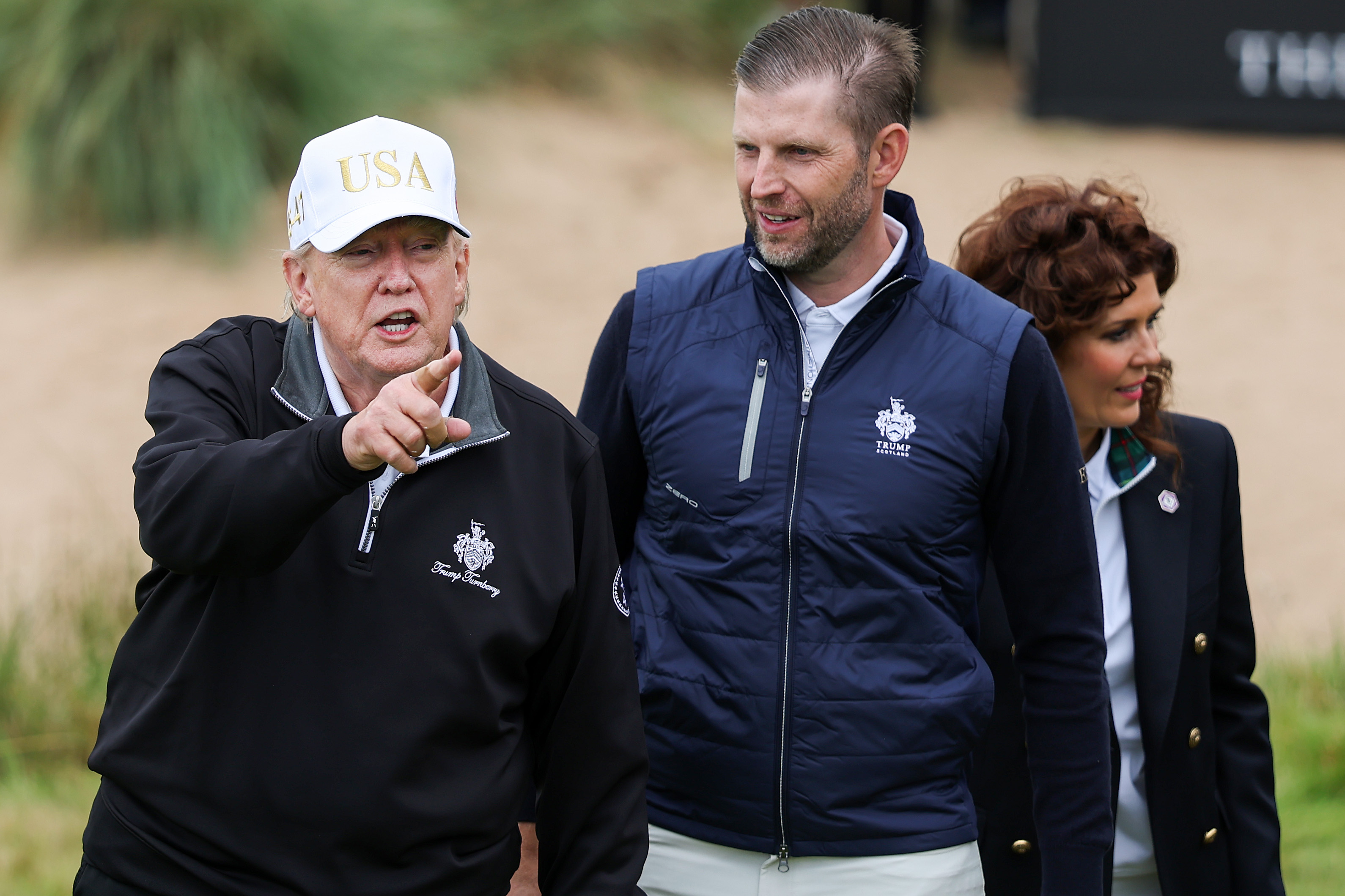 BALMEDIE, SCOTLAND - JULY 29: U.S. President Donald Trump cuts the ribbon next to Eric Trump (2nd R) and Sarah Malone, Executive Vice President and general manager of Trump international Golf Links Scotland (R) at the ribbon-cutting ceremony at a new 18-hole course at Trump International Golf Links on July 29, 2025 in Balmedie, near Aberdeen, Scotland. President Trump is visiting Scotland in a trip that’s part-vacation, part-work, as he stayed at his Trump Turnberry golf course, followed by Trump International Golf Links in Aberdeenshire, between July 25 to 29. (Photo by Jeff J Mitchell/Getty Images)
