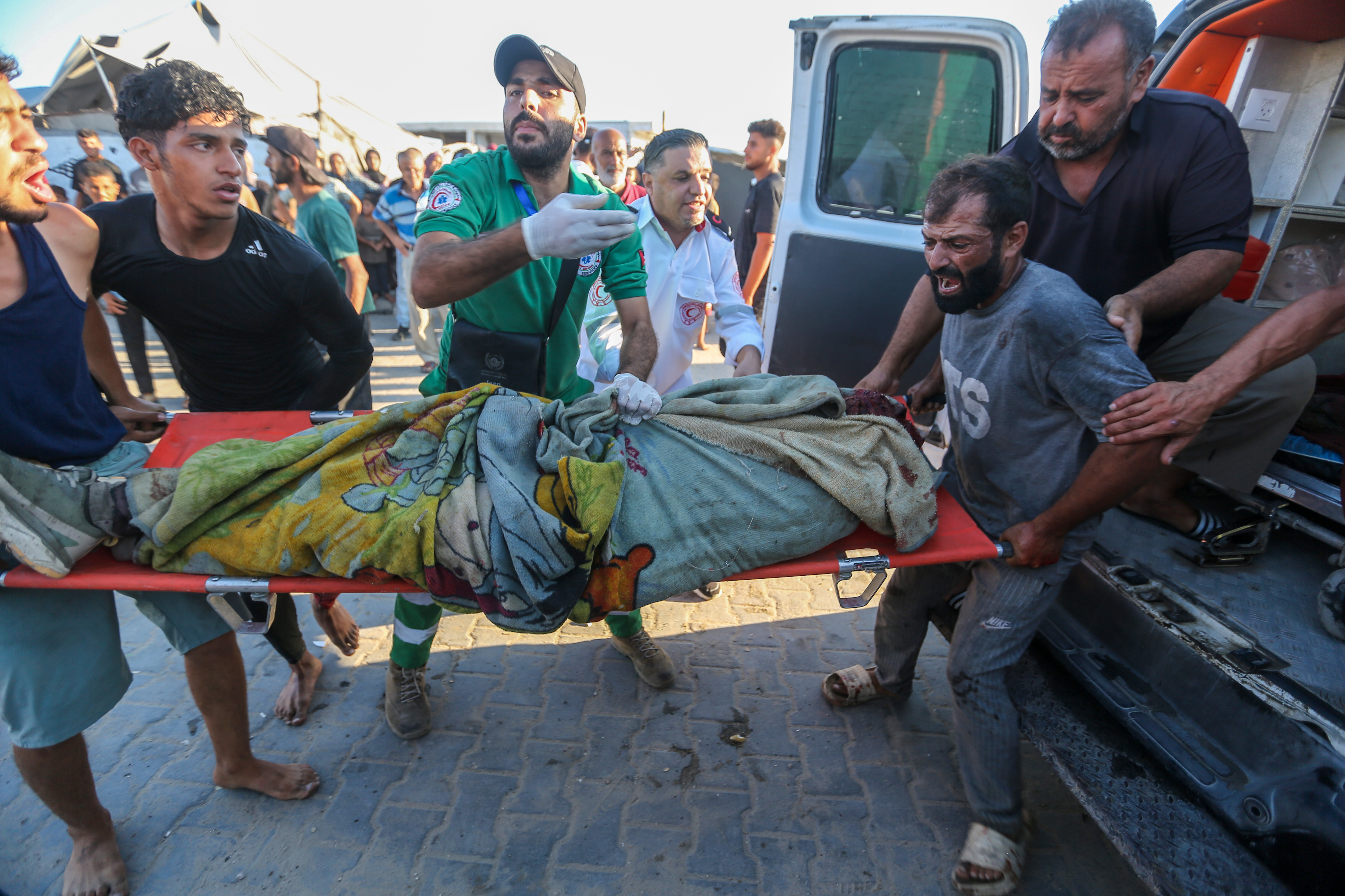 Paramedics carry the body of a person killed in an Israeli airstrike on August 18, 2026 in Gaza City, Gaza