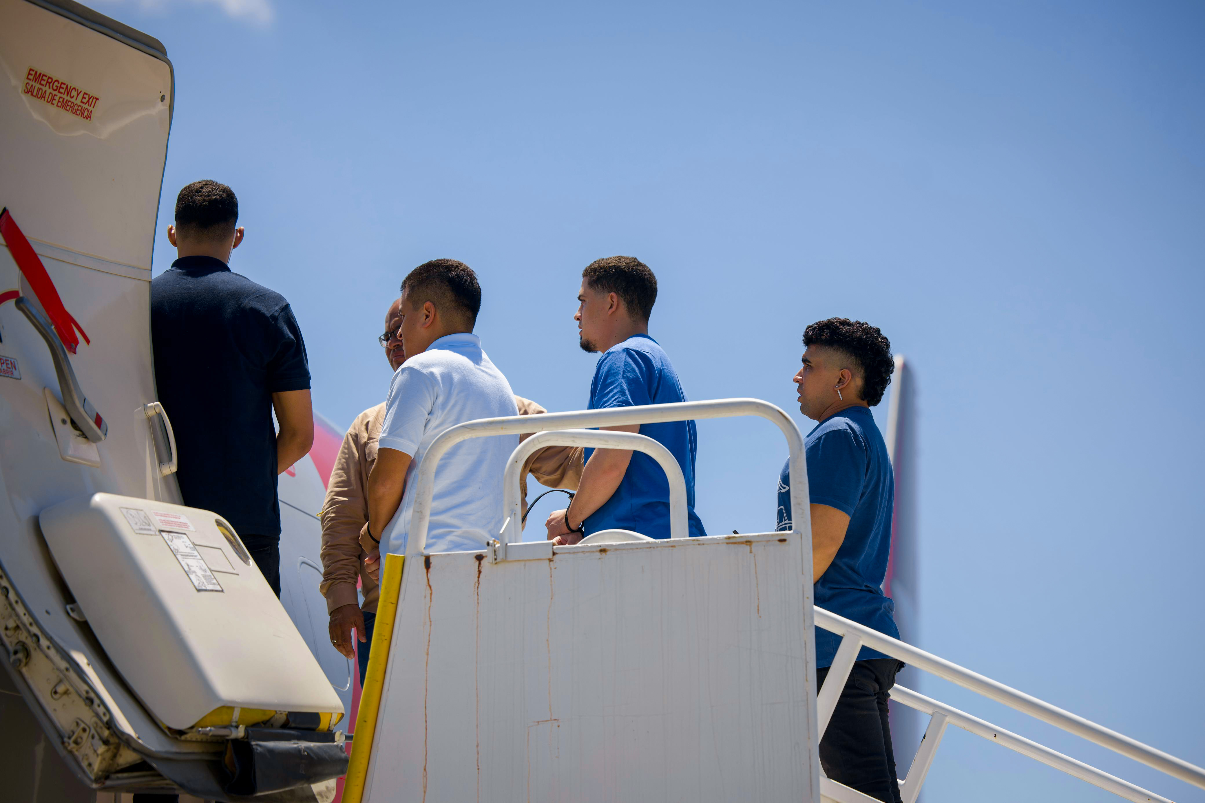 LA PAZ, EL SALVADOR - JULY 18: Detained Venezuelans board the flight to venezuela at San Óscar Arnulfo Romero y Galdámez International Airport as part of a detainee exchange agreement between Venezuela and United States on July 18, 2025 in La Paz, El Salvador. According to U.S government officials, 238 Venezuelans detainees held at maximum security CECOT prison in El Salvador, will be exchanged for five U.S. citizens and five U.S. permanent residents. The Venezuelans had been sent to El Salvador in March after U.S President Donald Trump invoked the 1798 Alien Enemies Act to deport presumed 'Tren de Aragua' gang members without passing under normal immigration processes. (Photo by El Salvador Presidency/Handout/Getty Images)