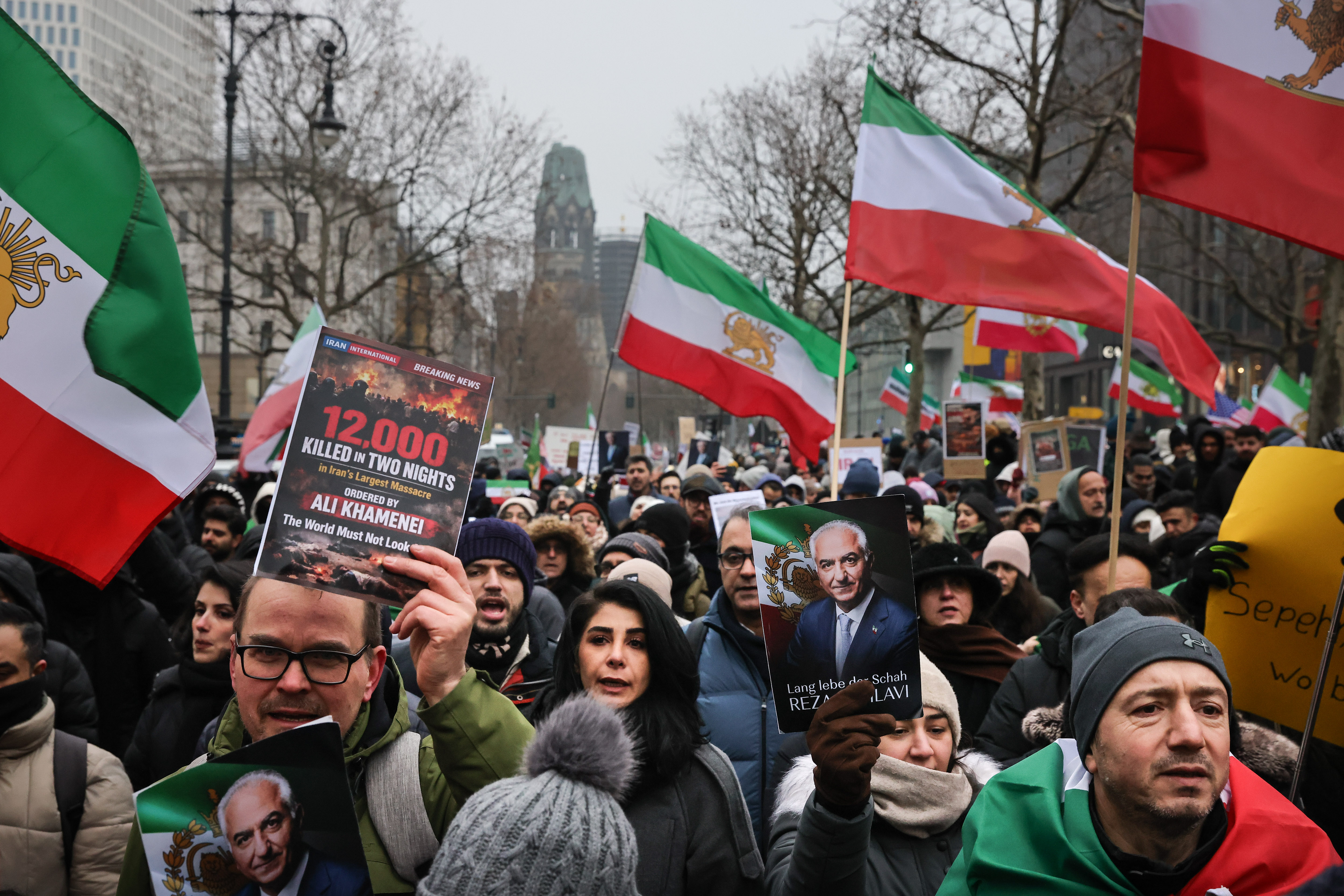 Demonstrators wave Shah-era Iranian flags and hold portraits of Reza Pahlavi, the exiled son of the deposed leader