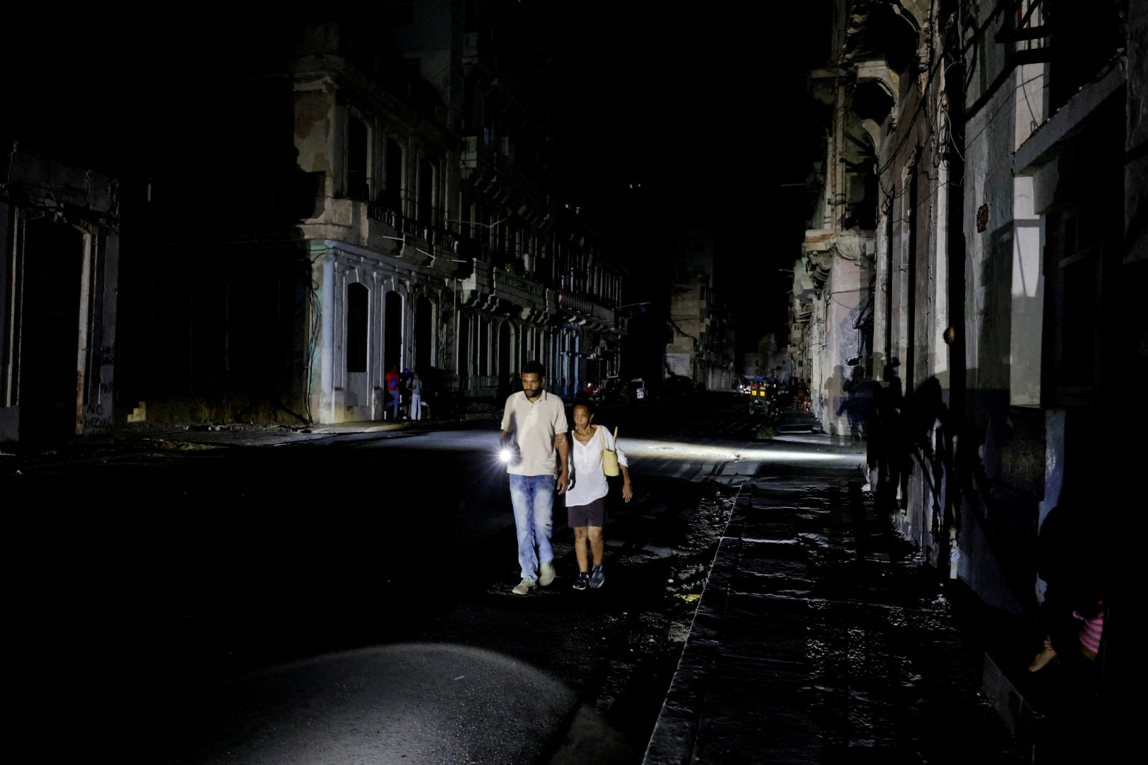 FILE PHOTO: People walk down a street as Cuba's national power grid collapsed, marking the third major outage in nine days, in Havana, Cuba, July 14, 2026. [Norlys Perez/File Photo/Reuters]