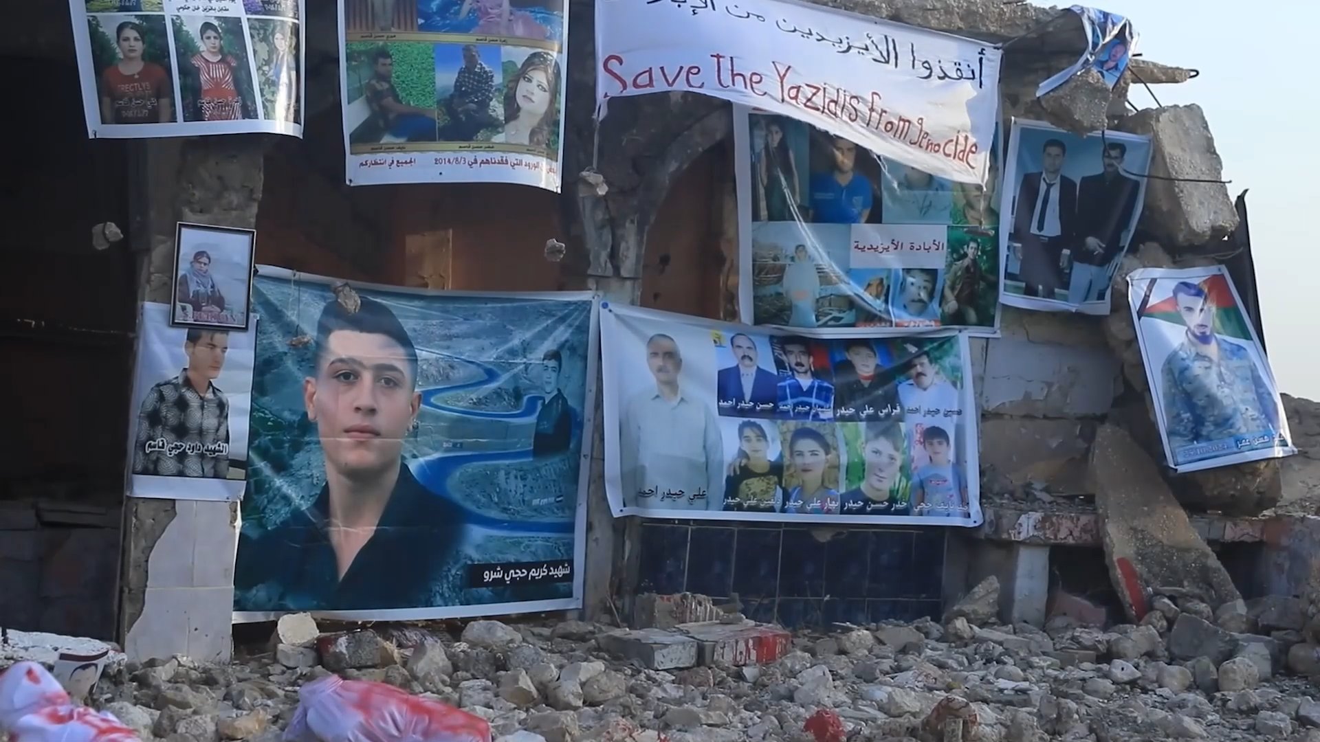 Posters depicting victims of attack by ISIL in August 2014 that killed scores of Yazidis. Sinjar, Iraq, August 4, 2026 [Screenshot from Viory File]