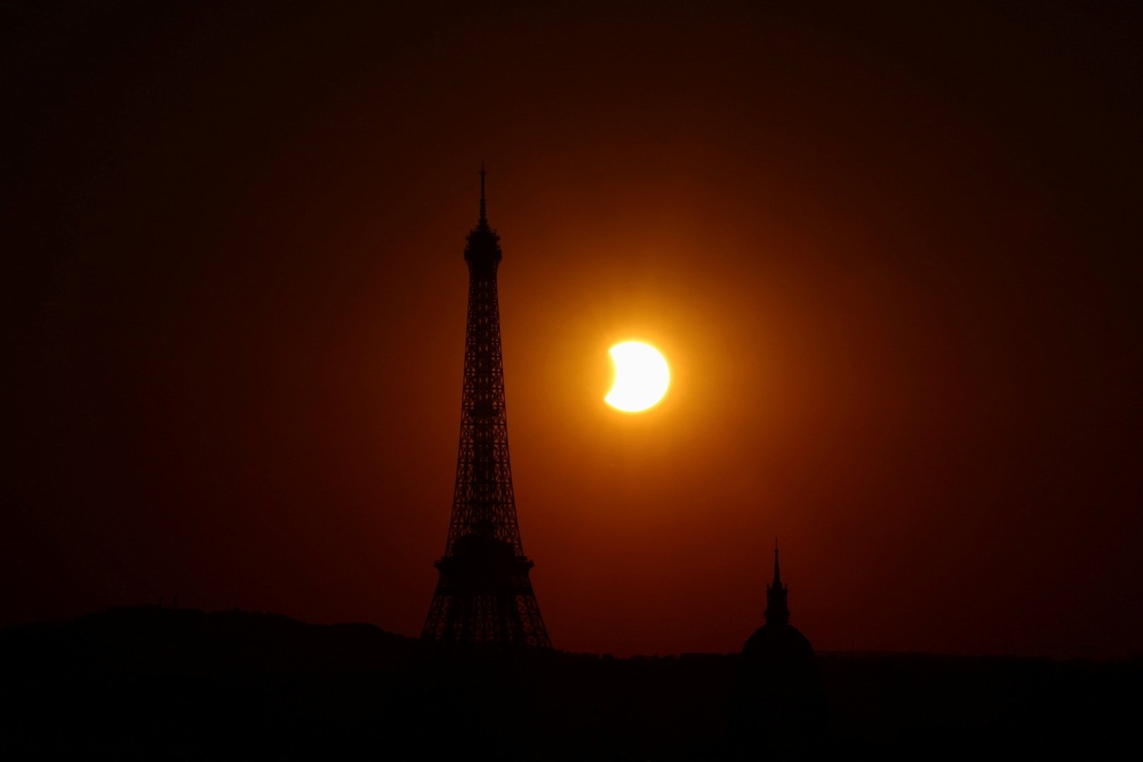 The Eiffel Tower is silhouetted as the moon partially covers the sun during a solar eclipse, as seen from Paris, France, August 12, 2026. [Sarah Meyssonnier/Reuters]