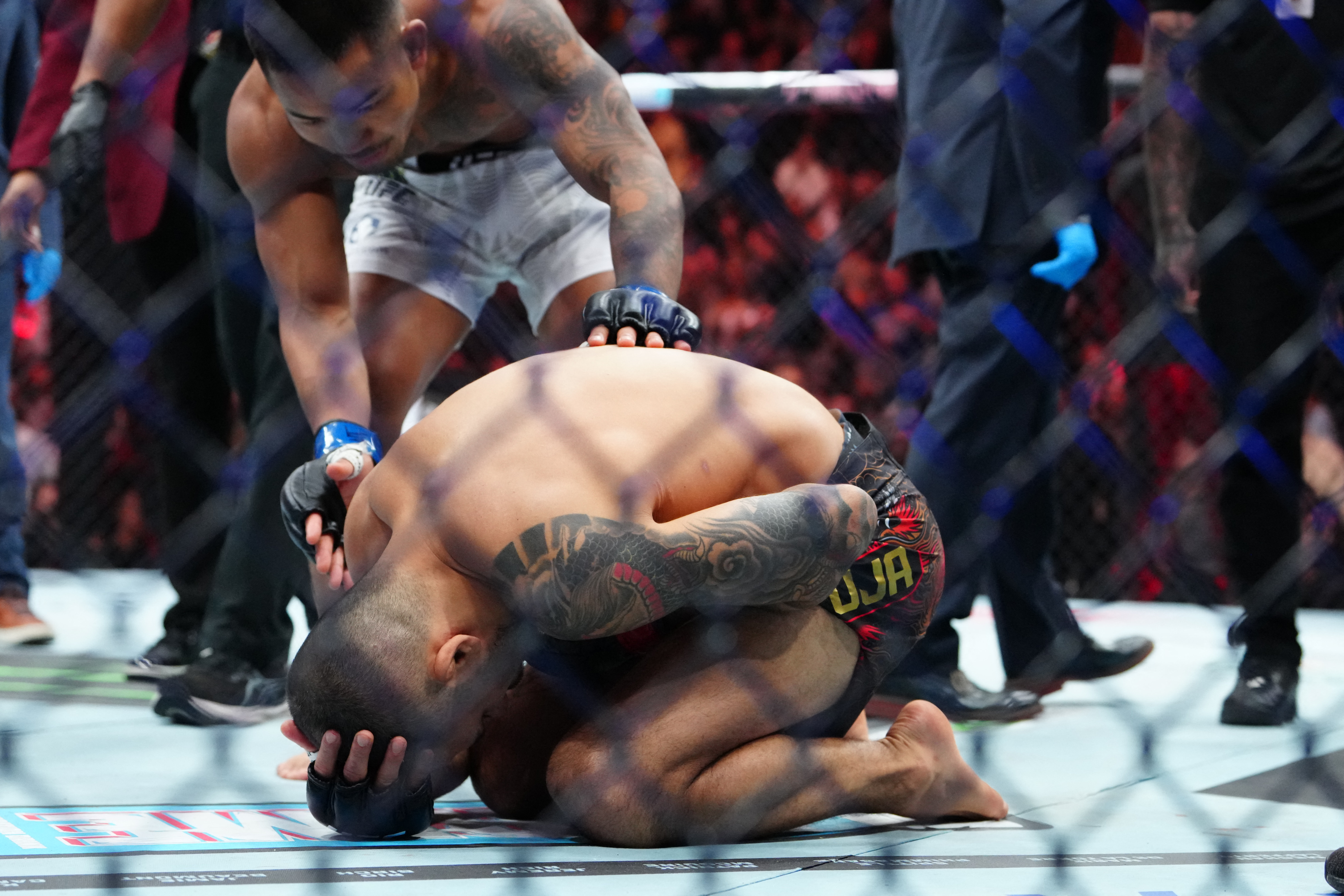 Dec 6, 2025; Las Vegas, Nevada, UNITED STATES; Alexandre Pantoja (red gloves) reacts after breaking an arm against Joshua Van (blue gloves) during UFC 323 at T-Mobile Arena. Mandatory Credit: Stephen R. Sylvanie-Imagn Images