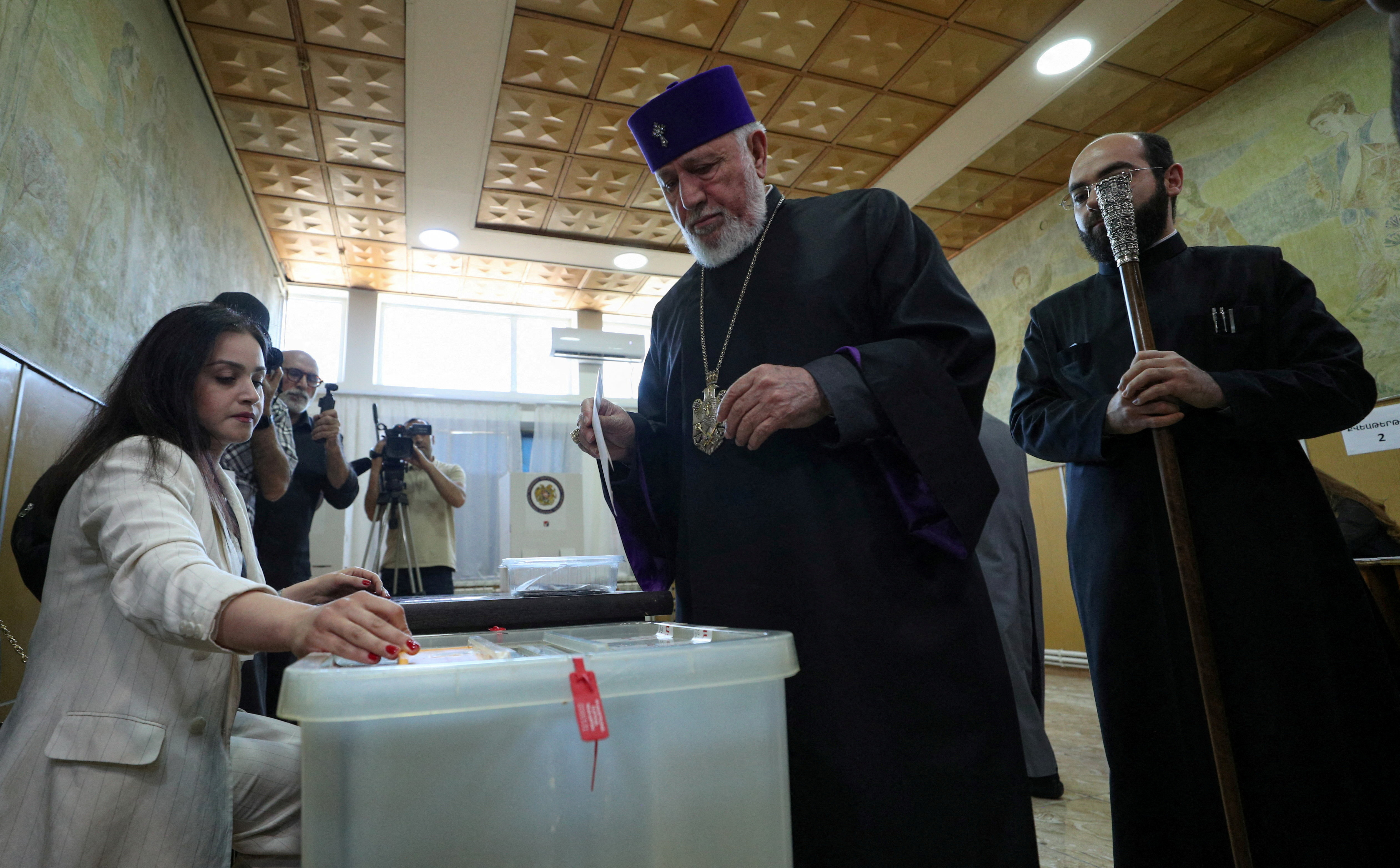 Catholicos Karekin II, head of the Armenian Apostolic Church, waits before casting a ballot at a polling station.