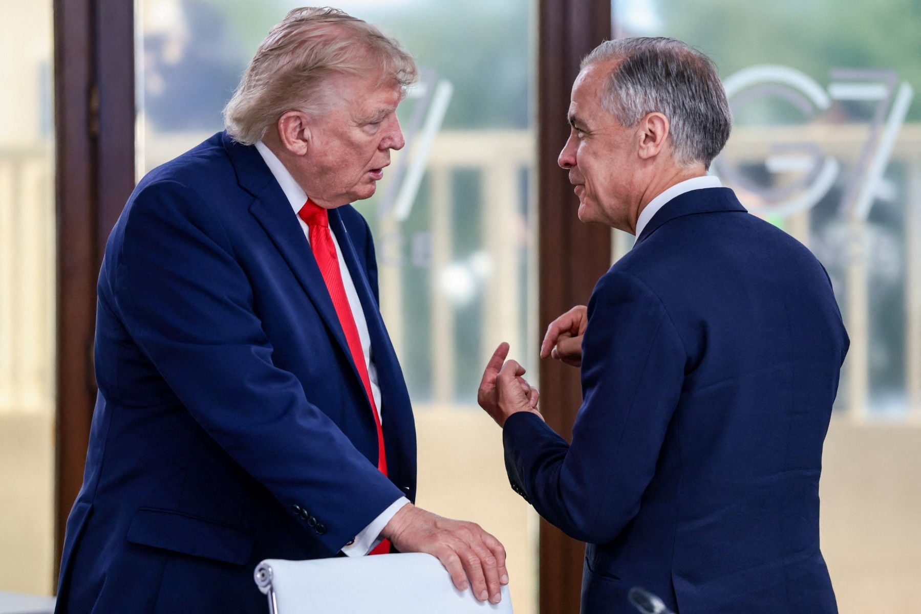 Two men in suits speak to each other