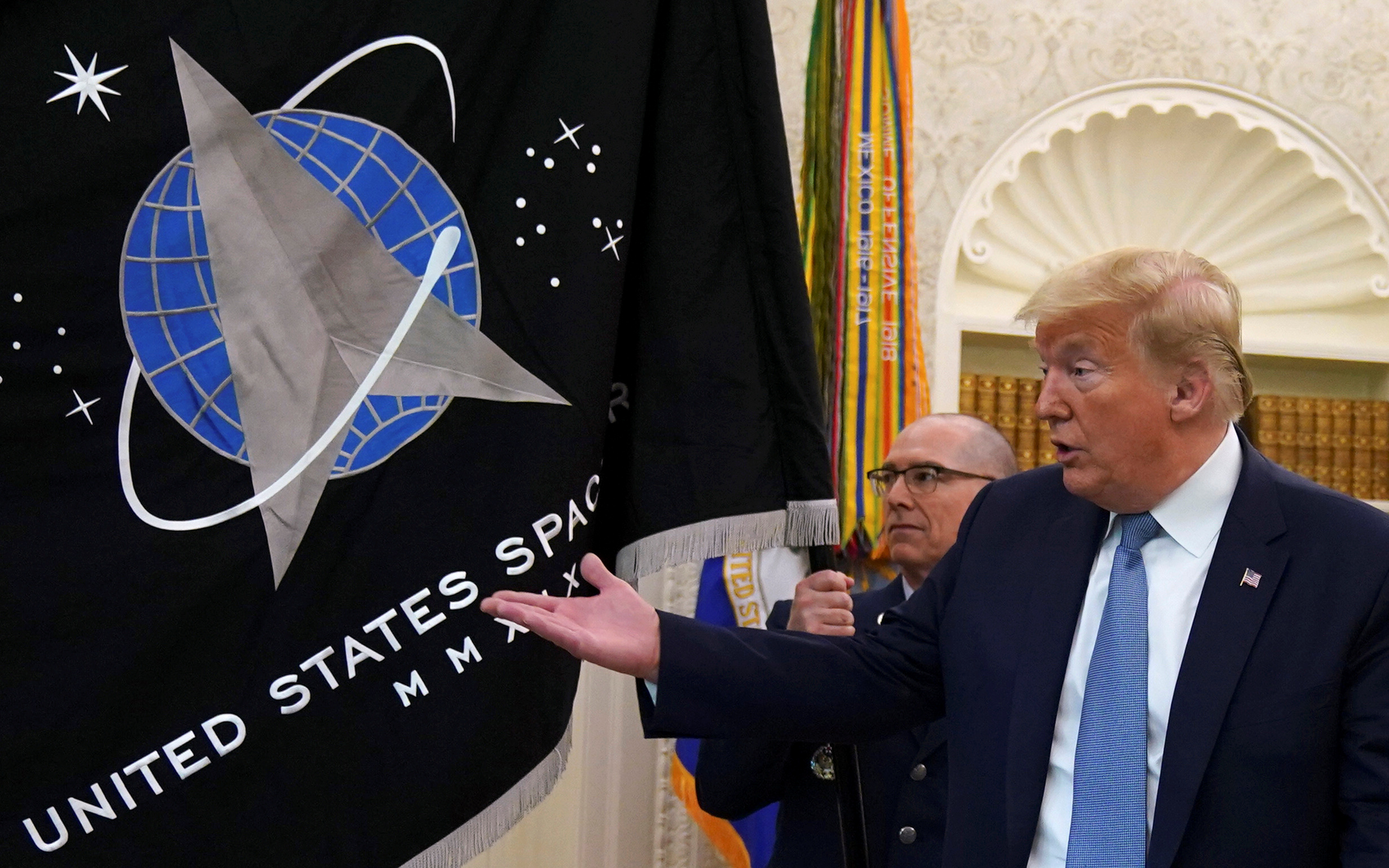 US President Donald Trump gestures towards the US Space Force flag during a presentation of the flag in the Oval Office of the White House in Washington, DC, the US, May 15, 2020