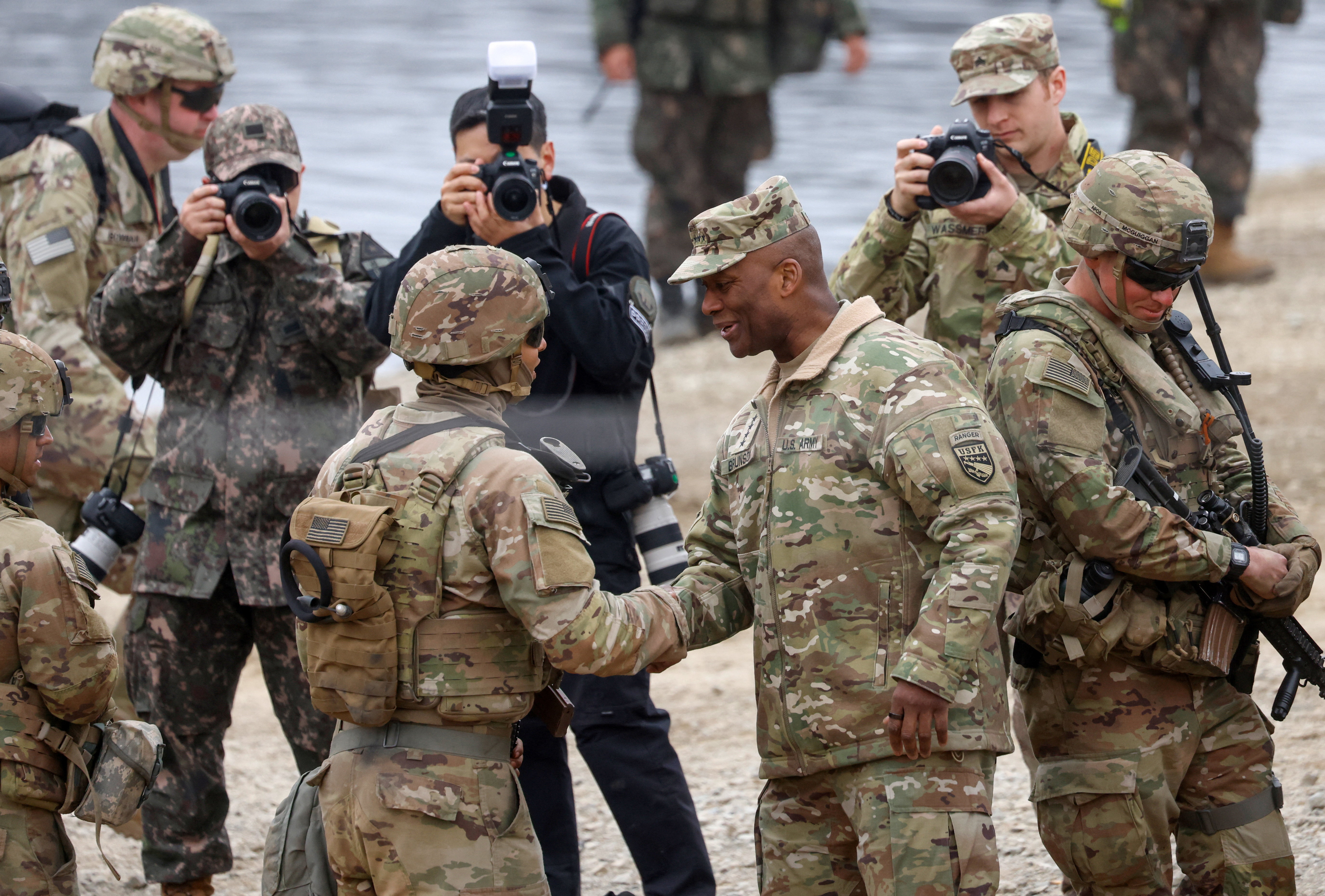 US General Xavier T. Brunson, commander of the ROK/US Combined Forces Command (CFC), the United States Forces Korea (USFK) and the United Nations Command (UNC), shakes hands with a US Army soldier during a US-South Korea joint river-crossing exercise, which is a part of the annual Freedom Shield joint military training, near the demilitarised zone separating South and North Korea, in Yeoncheon, South Korea [Kim Soo-hyeon/Reuters]