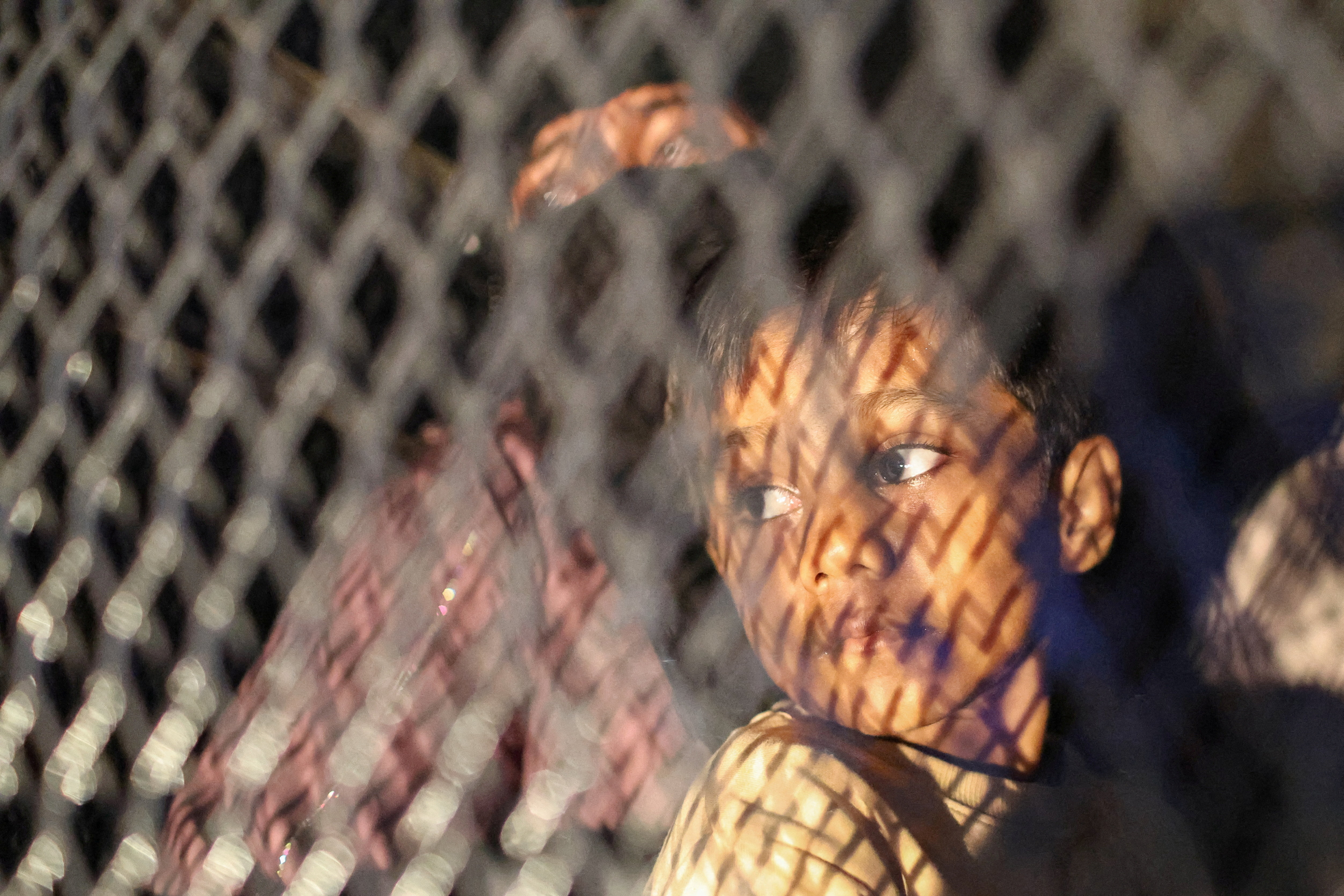 Rohingya refugees sit inside a truck as they are taken by police, in front of the office of the U.N. Refugee Agency, after being evicted from their homes