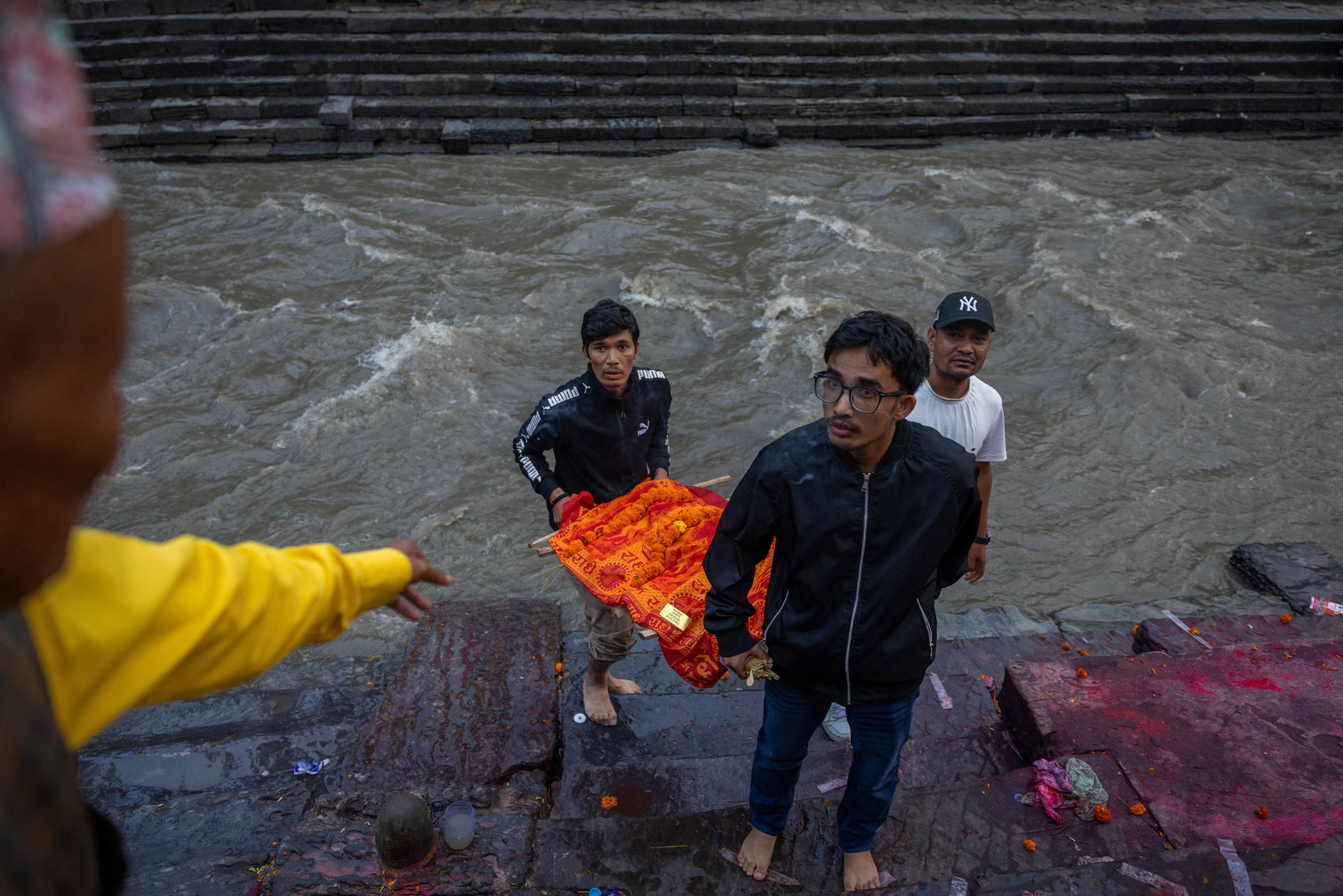 Sujan Achhami (front) helps to carry a symbolic effigy of his father, Dinesh, who died in deadly flash floods and a mudslide, for a cremation ceremony because his body has not been recovered, at Pashupatinath Temple in Kathmandu, Nepal, on September 3, 2026