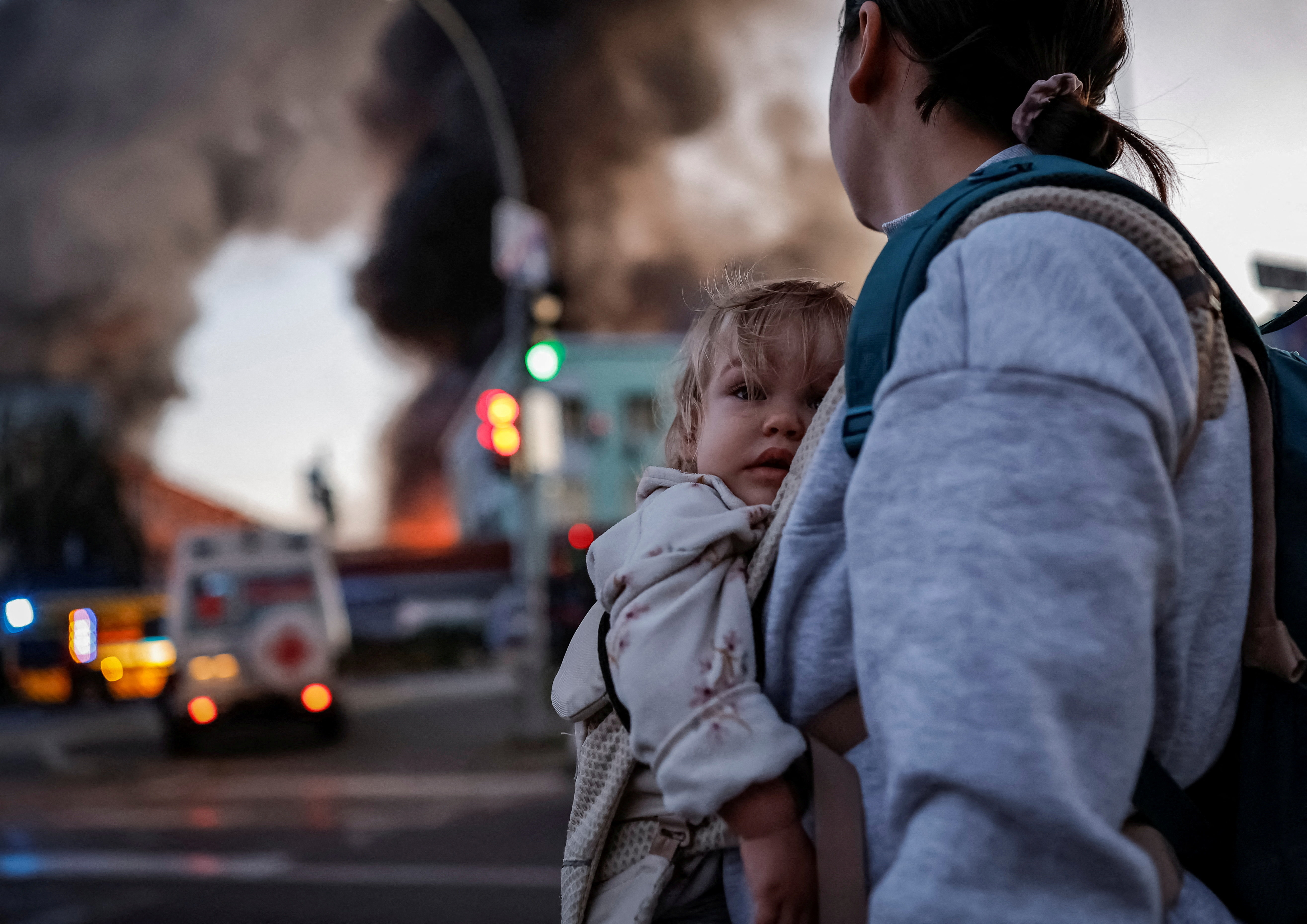 A woman with a child walks at the site of a Russian missile strike, leaving a shelter, amid Russia's attack on Ukraine, in Kyiv, Ukraine September 8, 2026. REUTERS/Yan Dobronosov TPX IMAGES OF THE DAY