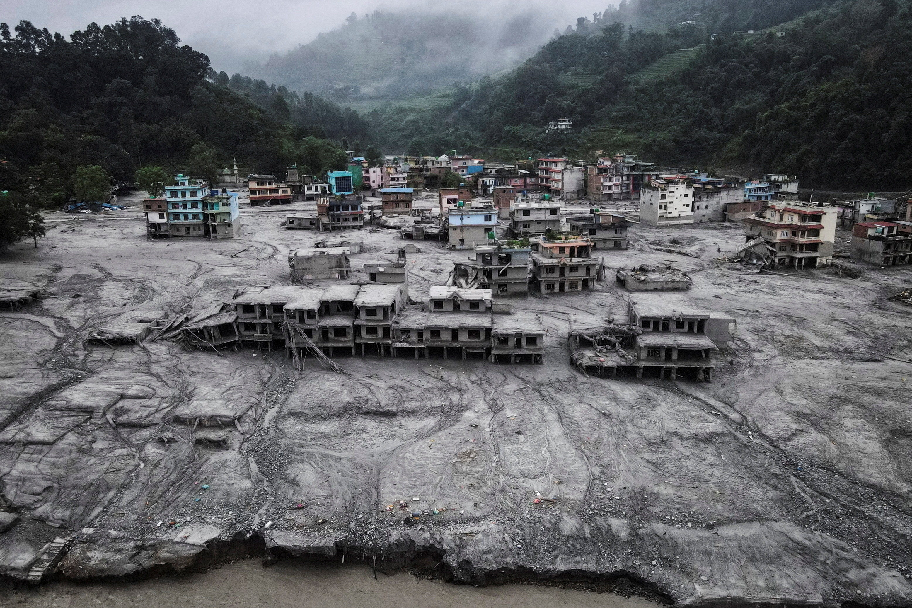 A drone view shows houses covered in mud after the flash floods and mudslide, at Devighat, Nuwakot district, Nepal, August 29, 2026. REUTERS/Francis Mascarenhas SEARCH "NEPAL FLOOD PICTURES" FOR THIS STORY. SEARCH "WIDER IMAGE" FOR ALL STORIES.