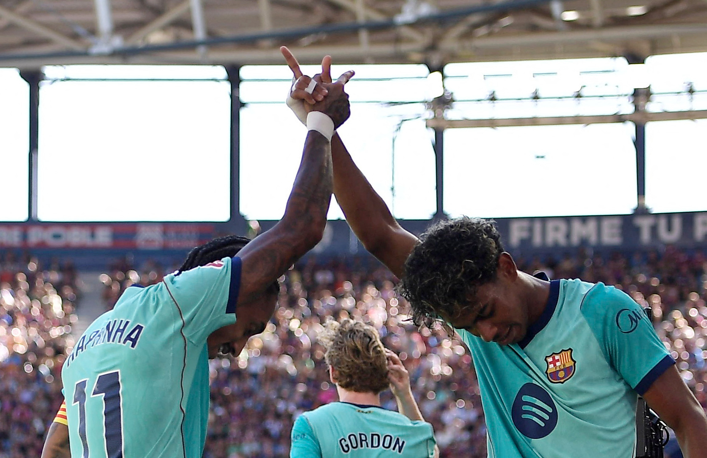 Lamine Yamal and Raphinha celebrate together on the pitch