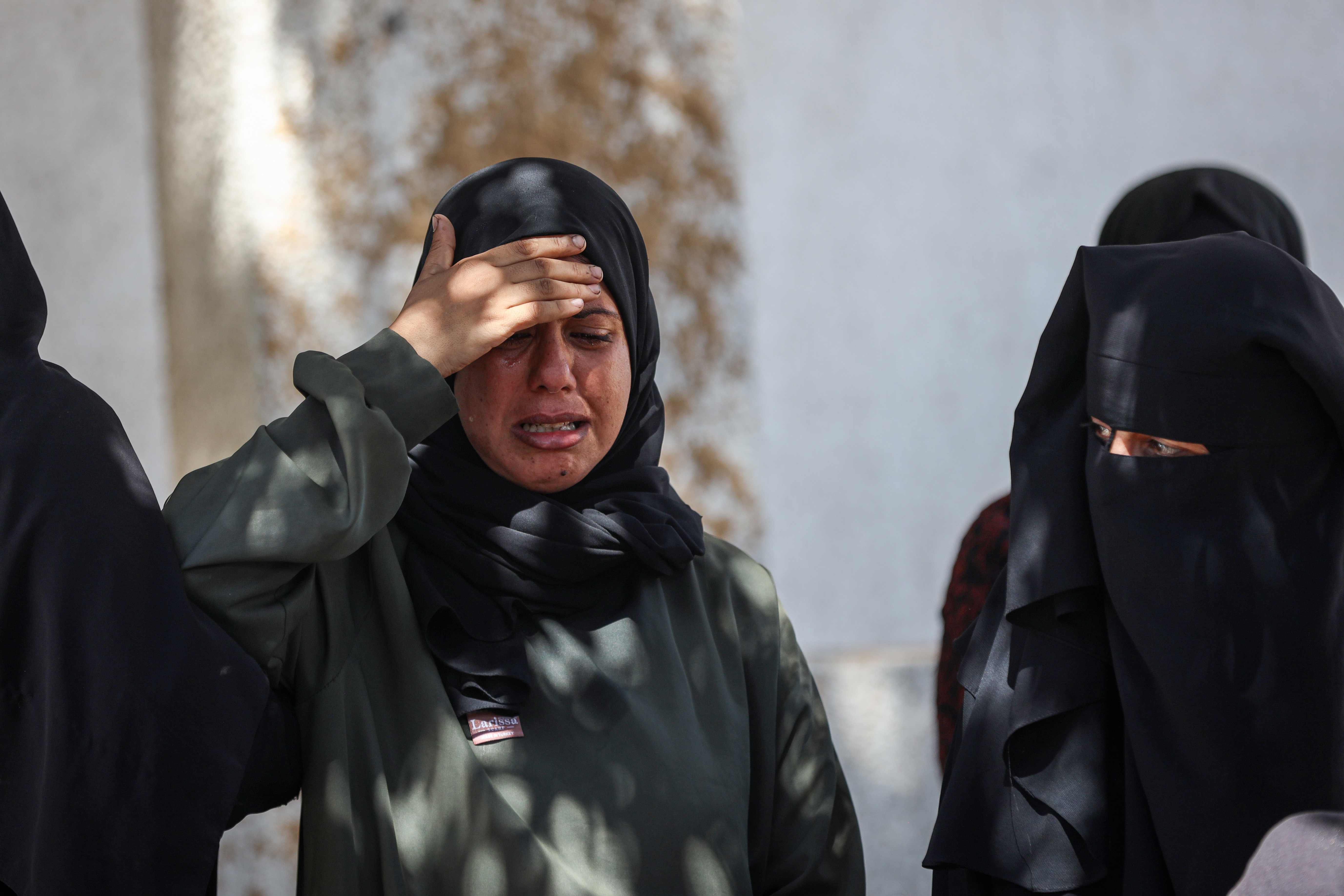 A woman holding her hand to her head and crying