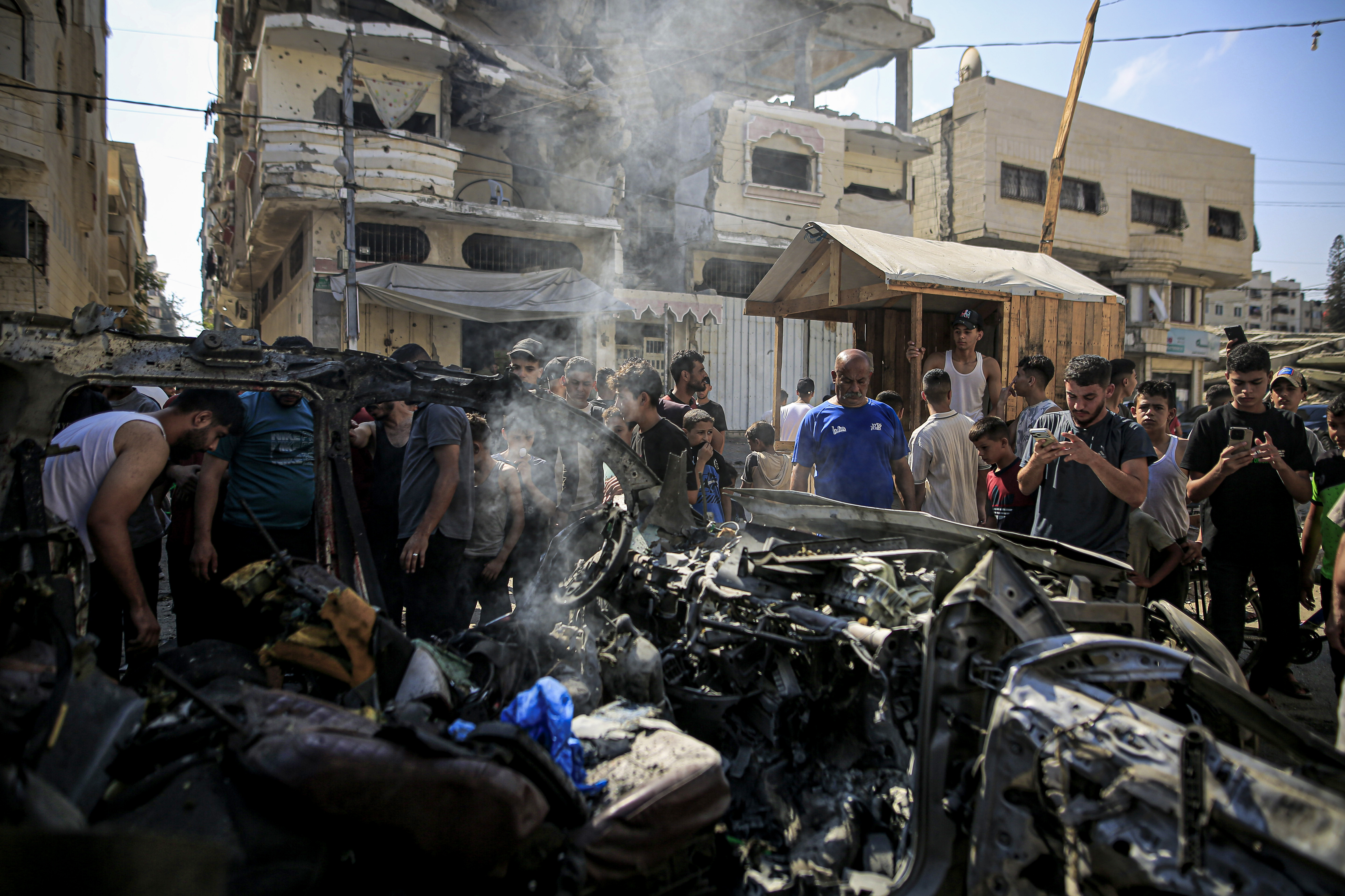 Palestinians gather to inspect the wreckage and damage at the site following an Israeli attack