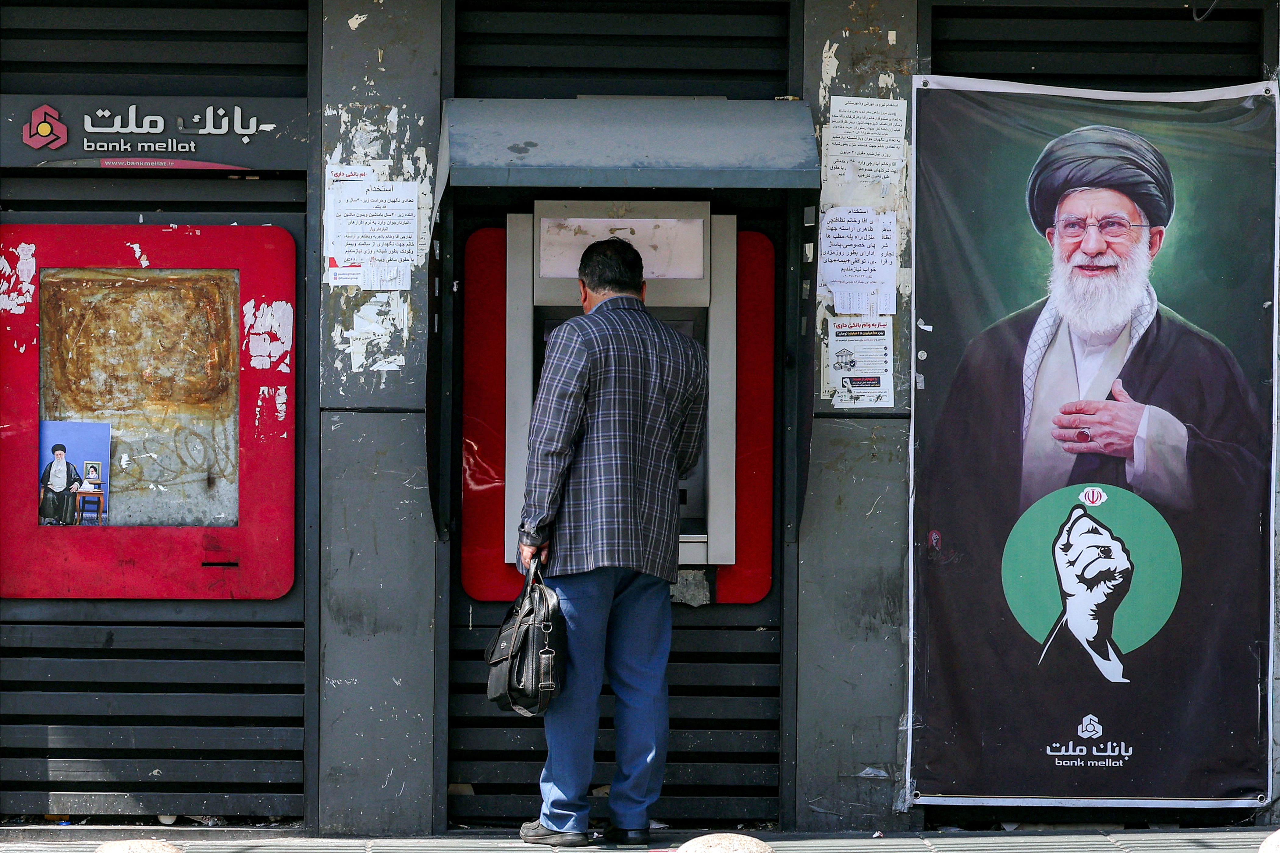 A man uses an automated teller machine (ATM).