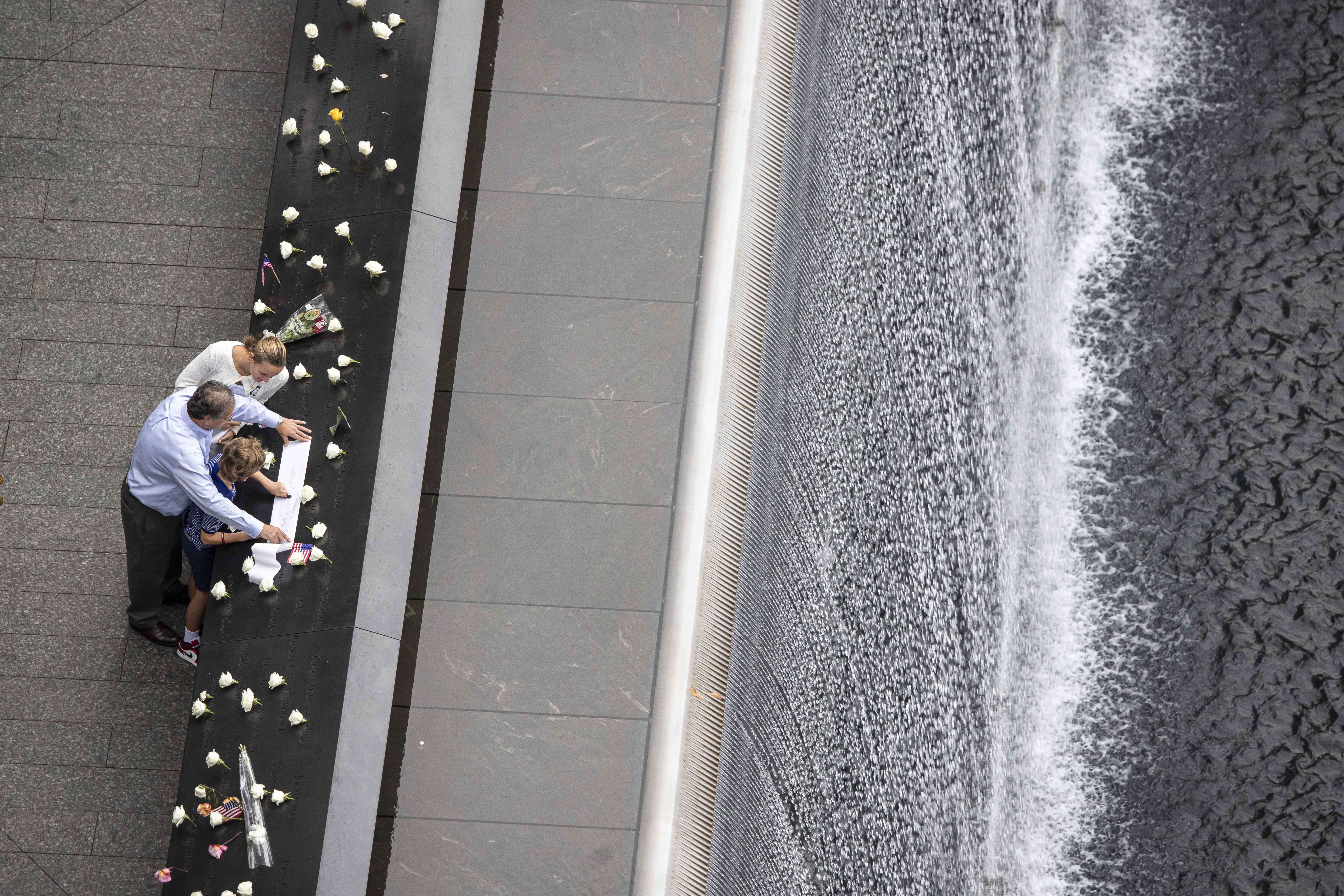 People make an etching of a name at the memorial during the 25th anniversary commemoration of the September 11, 2001 attacks at the National September 11 Memorial in New York on September 11, 2026. (Photo by Dave Sanders / POOL / AFP)