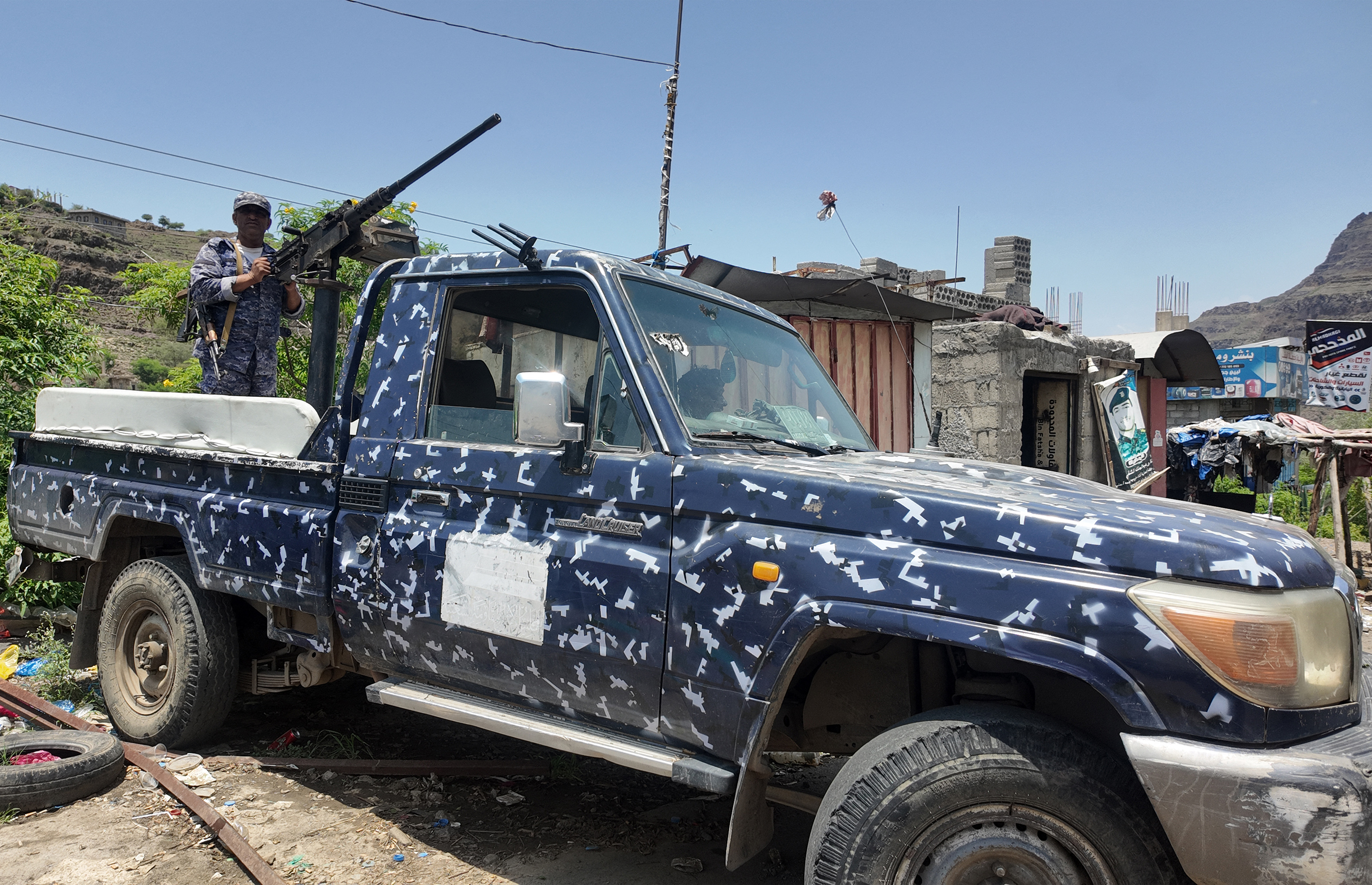 A member of the Saudi-backed Yemeni government forces, including National Army and Taiz Axis forces, mans a turret mounted on the back of a pick-up truck at a checkpoint along the Kadha front line west of Taiz in western Yemen [AFP]