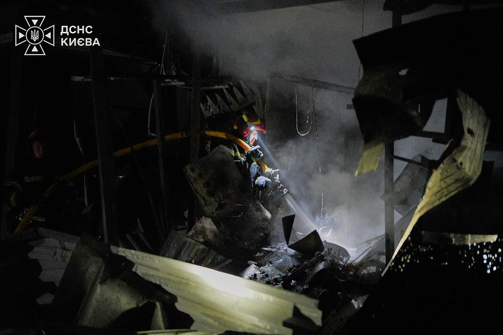 Ukrainian firefighters put out a fire following a Russian missile attack in Kyiv
