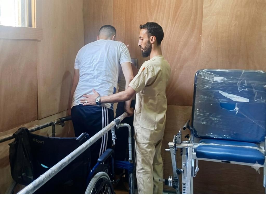 Physical therapist Jamal Kallab supervises the training of a man with an amputated leg in a rehabilitation centre in Gaza