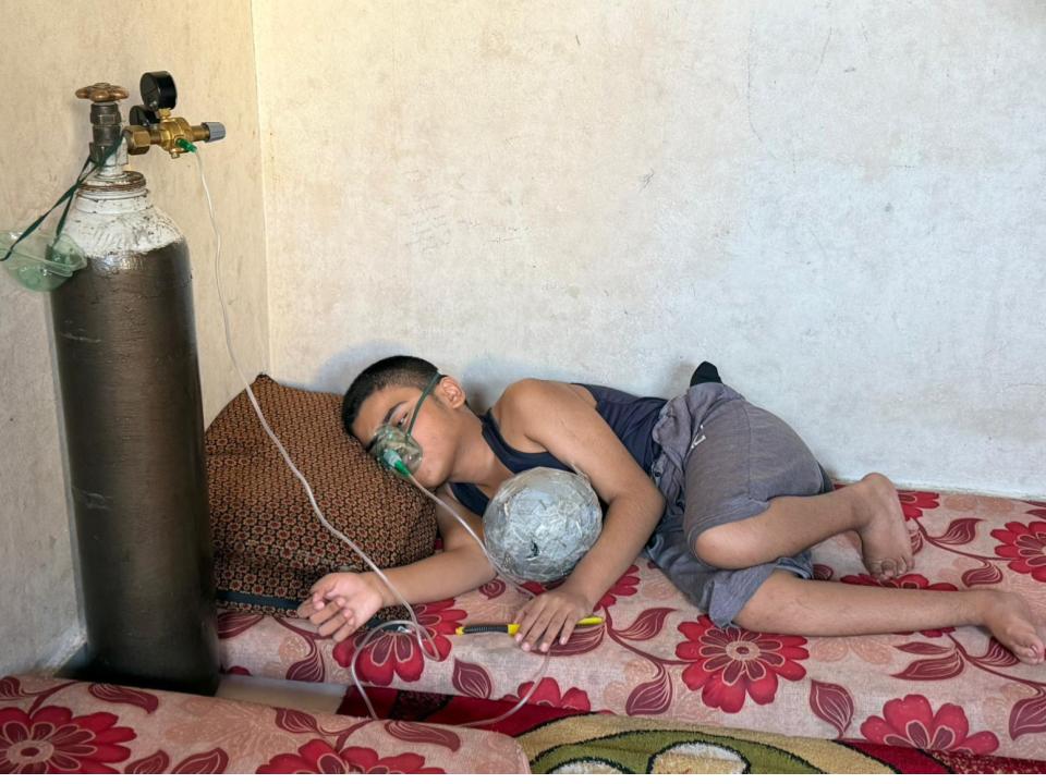 Abdulaziz Humaida lies down while an oxygen mask sits on his face