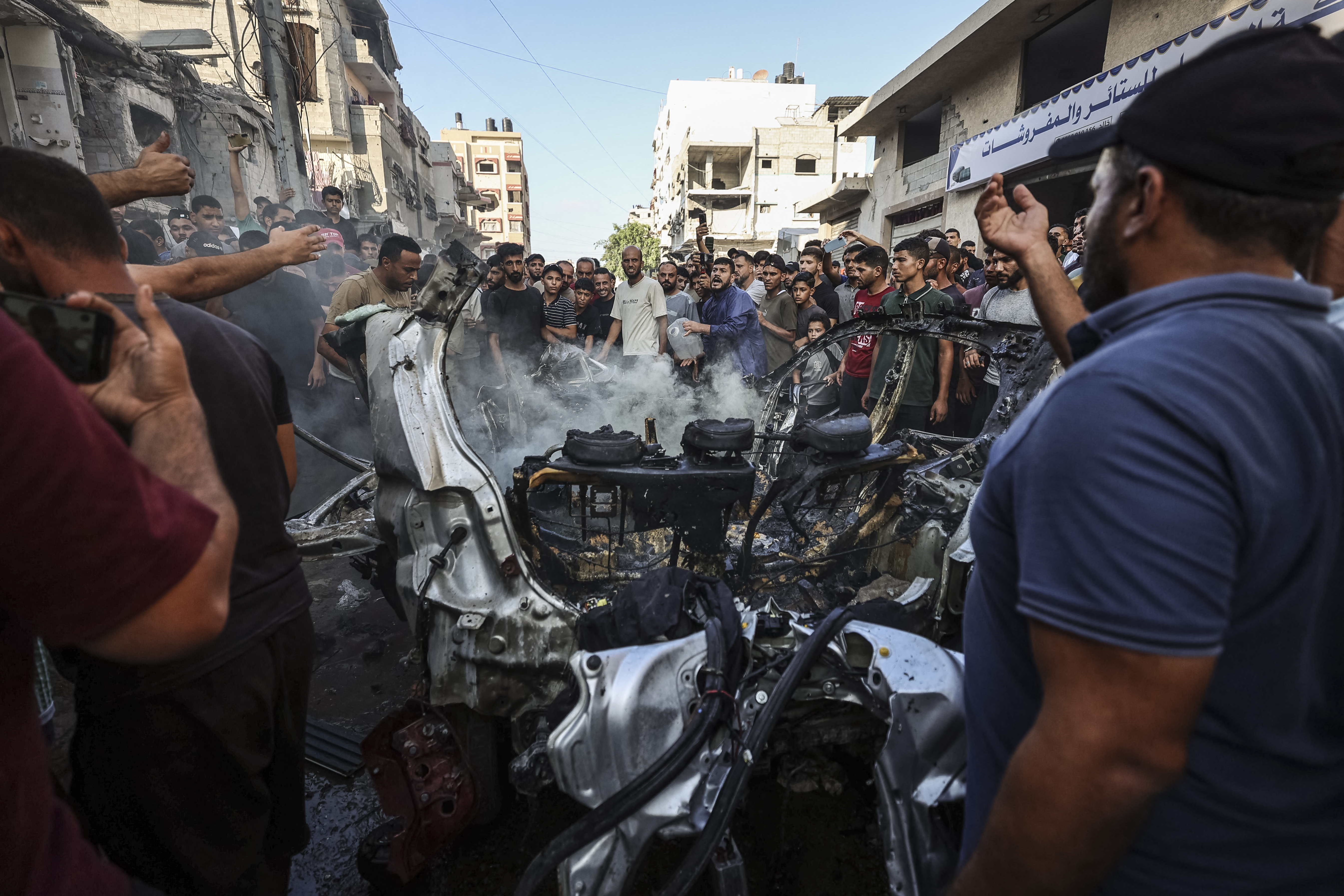 Palestinians gather around the site of an Israeli strike on a car that killed a man and a child, in Gaza City, on September 6, 2026.