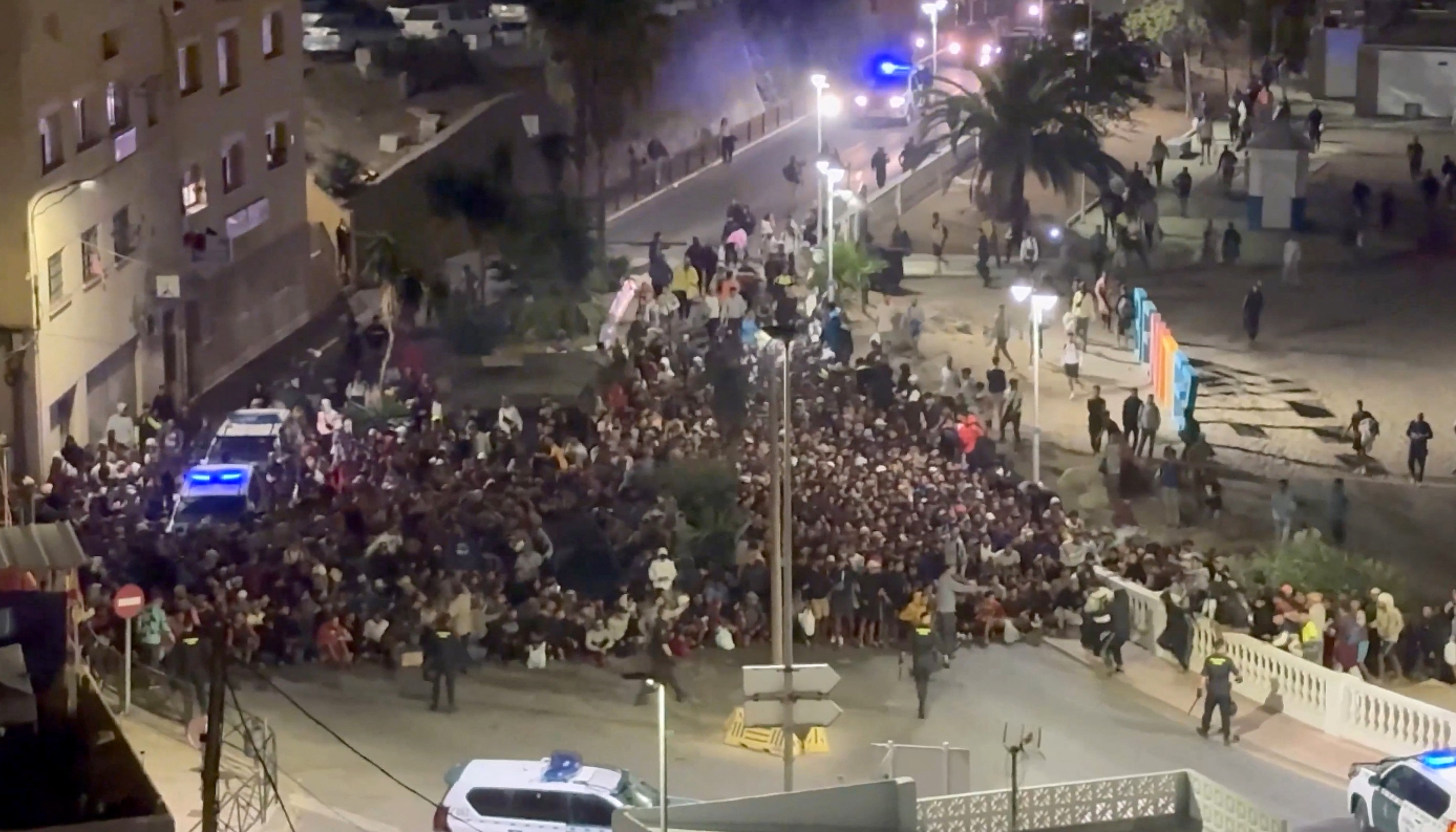 This screen grab made from UGC footage taken and released on September 18, 2026 shows hundreds of migrants from the beaches of Ceuta being rounded up by police before they were moved to a temporary camp in the Spanish enclave's port area, weeks after a record influx overwhelmed the tiny territory.