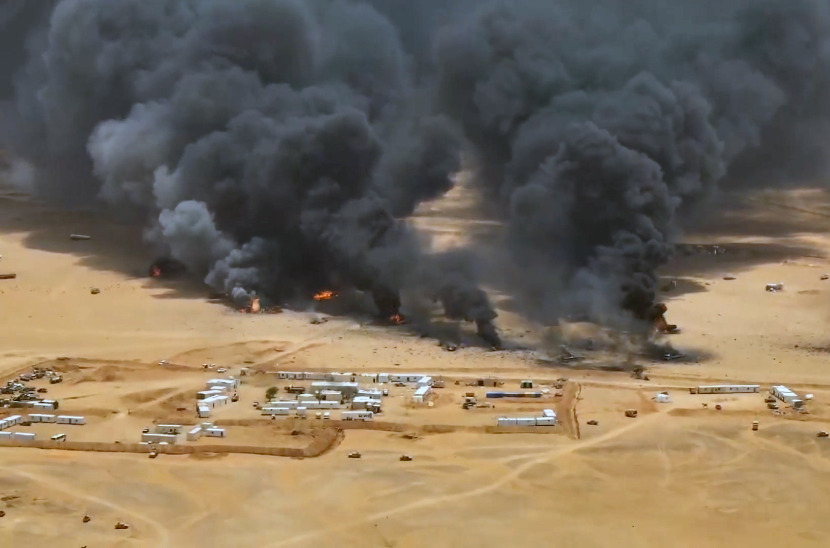 A handout screen grab taken from a video made available by the Houthi rebel group shows smoke and balls of fire rising from trucks at a camp of the Saudi-backed government forces following an alleged Houthi missile strike, in the eastern province of Hadramout, Yemen. [EPA]
